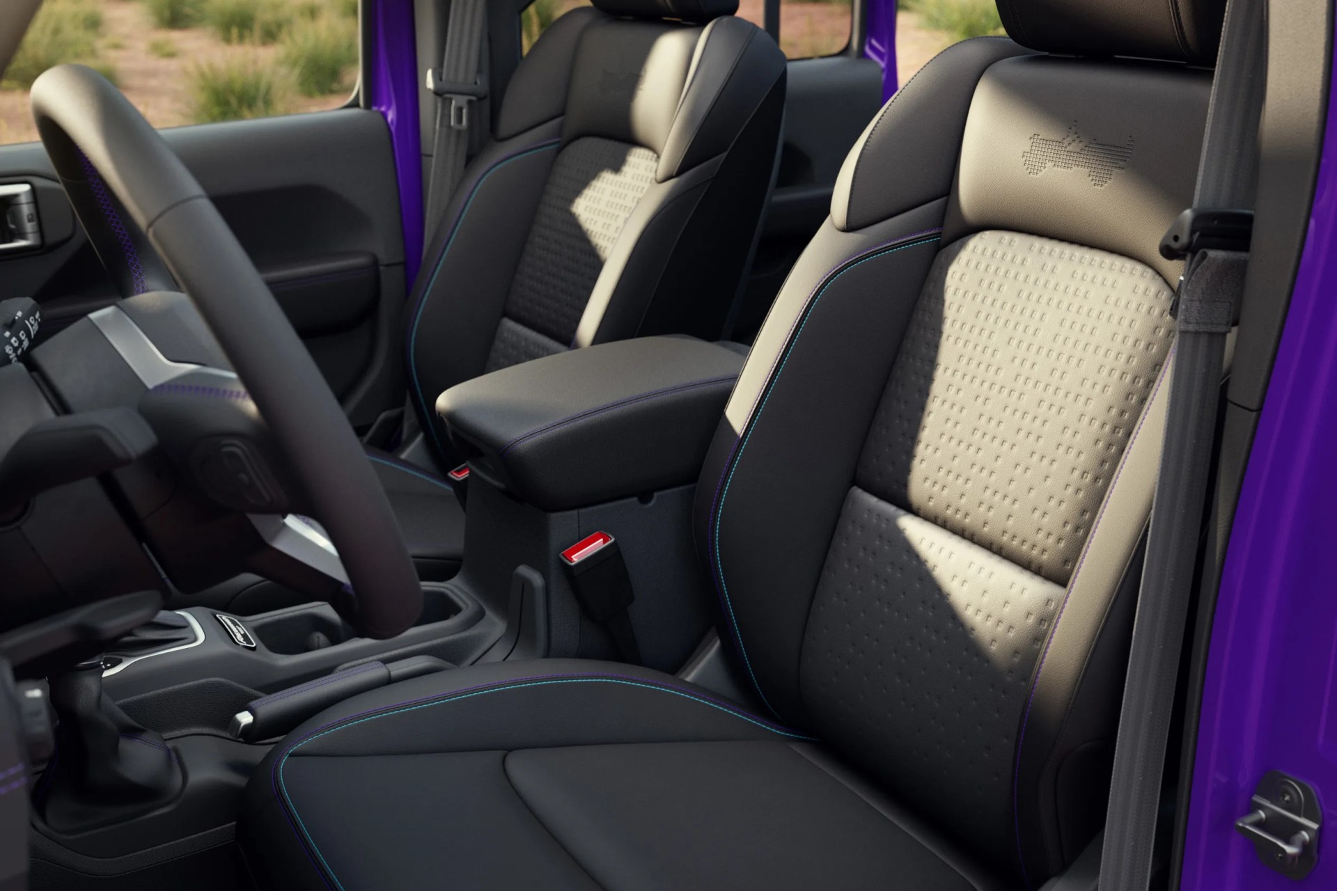 Black and gray leather car seats with blue and purple stitching inside a purple vehicle.