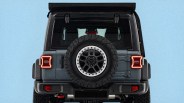 Rear view of a gray off-road SUV with a spare tire mounted on the back and illuminated taillights.