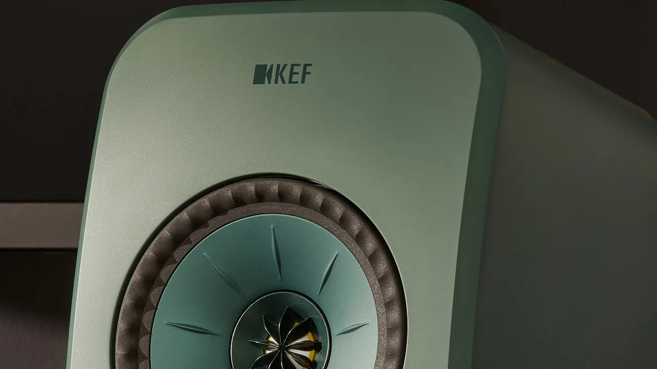Close-up of a green KEF speaker with a central cone and foam surround.