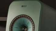 Close-up of a green KEF speaker with a central cone and foam surround.