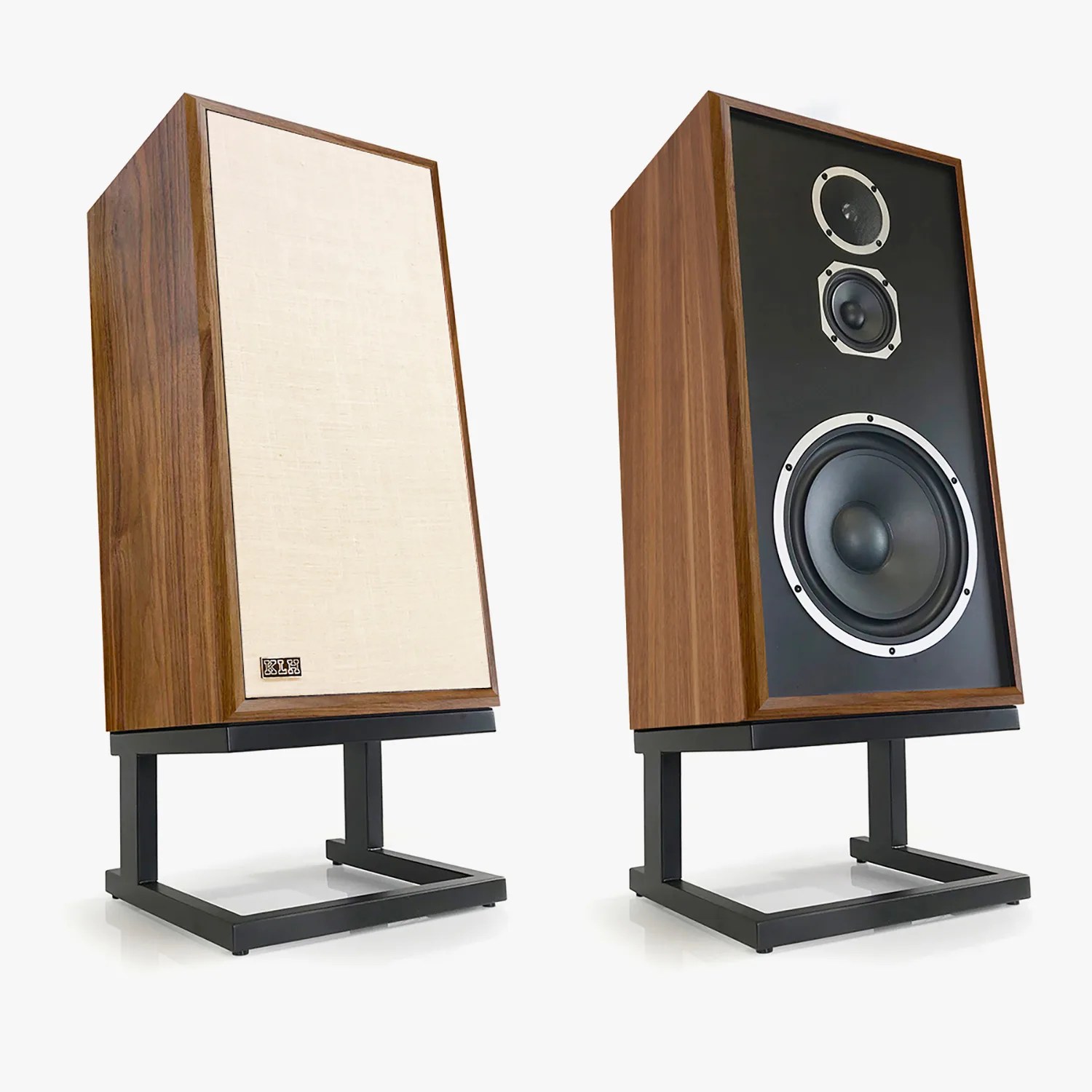 Pair of vintage-style wooden speakers with black metal stands, one with beige fabric cover and the other showing three speaker drivers.