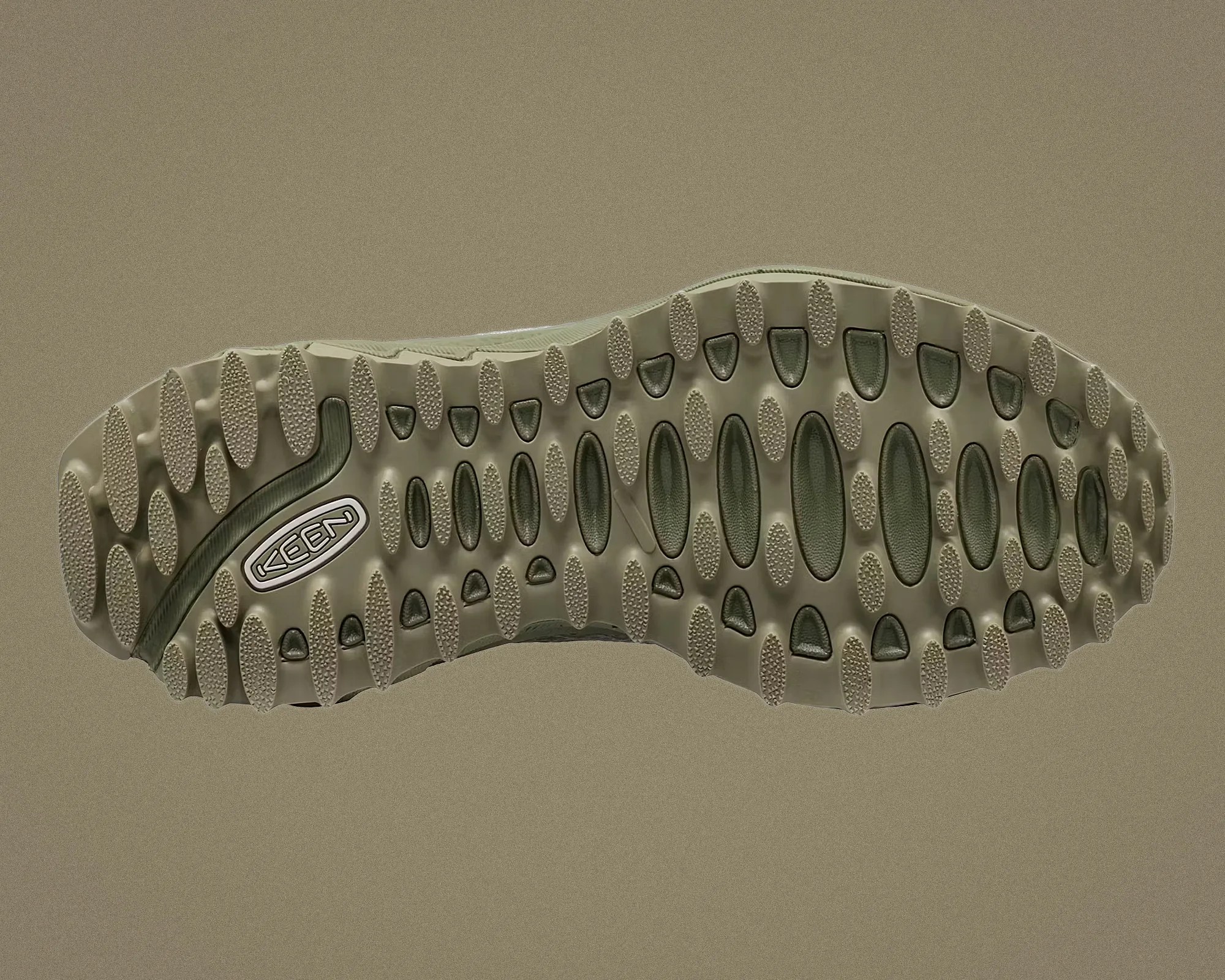 Olive green KEEN shoe sole with oval and triangular tread patterns on a matching olive background.