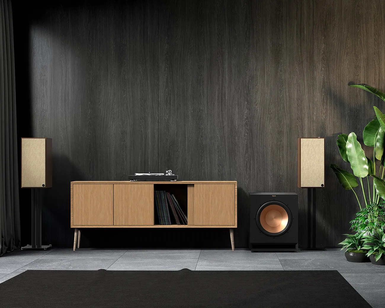 Modern audio setup with wooden cabinet holding vinyl records and turntable, flanked by beige speakers on black stands and a black subwoofer with copper cone, against a dark wood wall with green plants on the right.