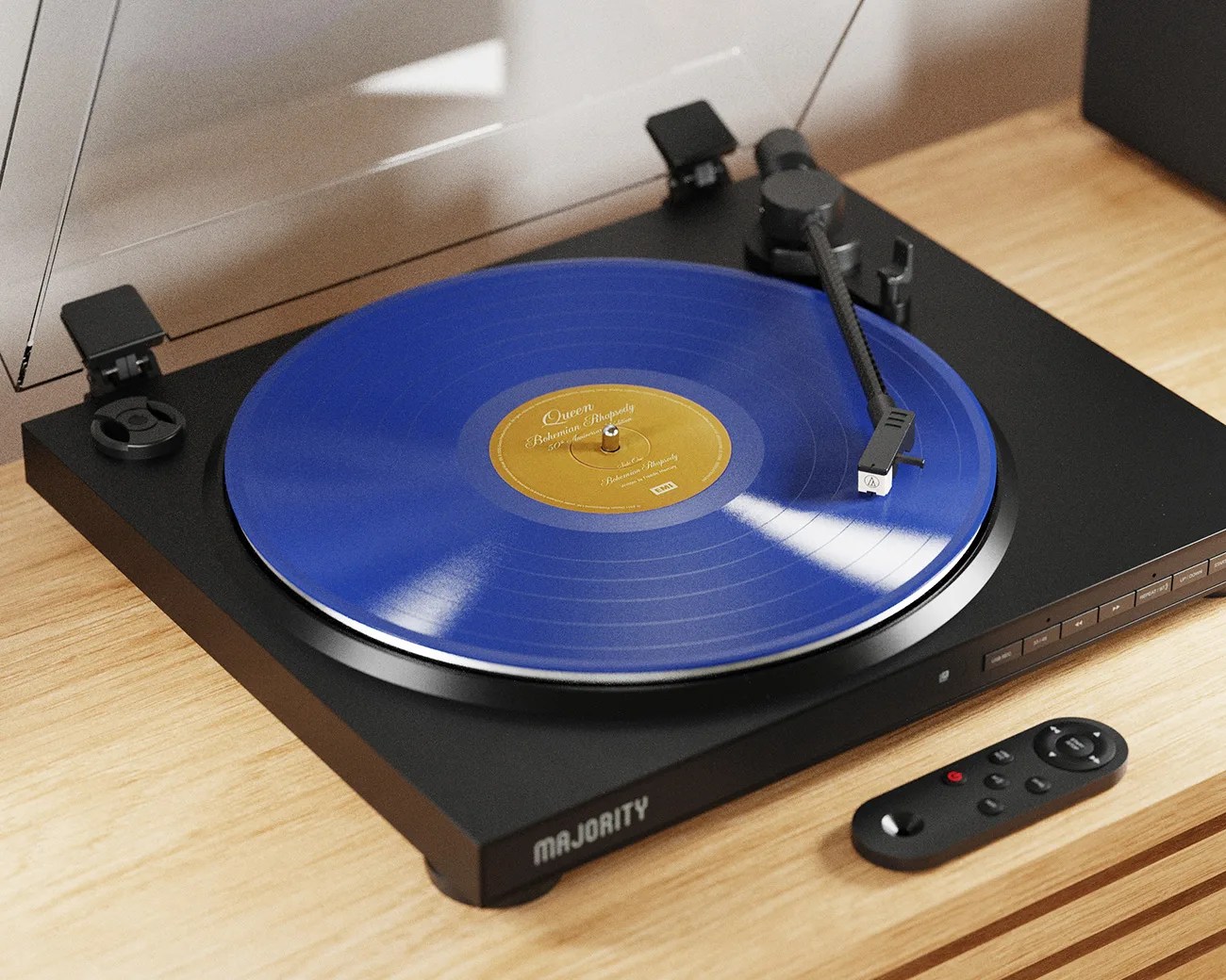 Black Majority turntable with a blue Queen "Bohemian Rhapsody" vinyl record on a wooden surface, accompanied by a black remote.