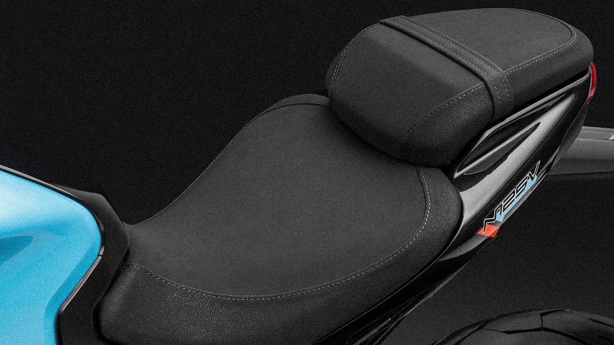 Black textured motorcycle seat with a raised passenger section and "V125V" decal on the side.