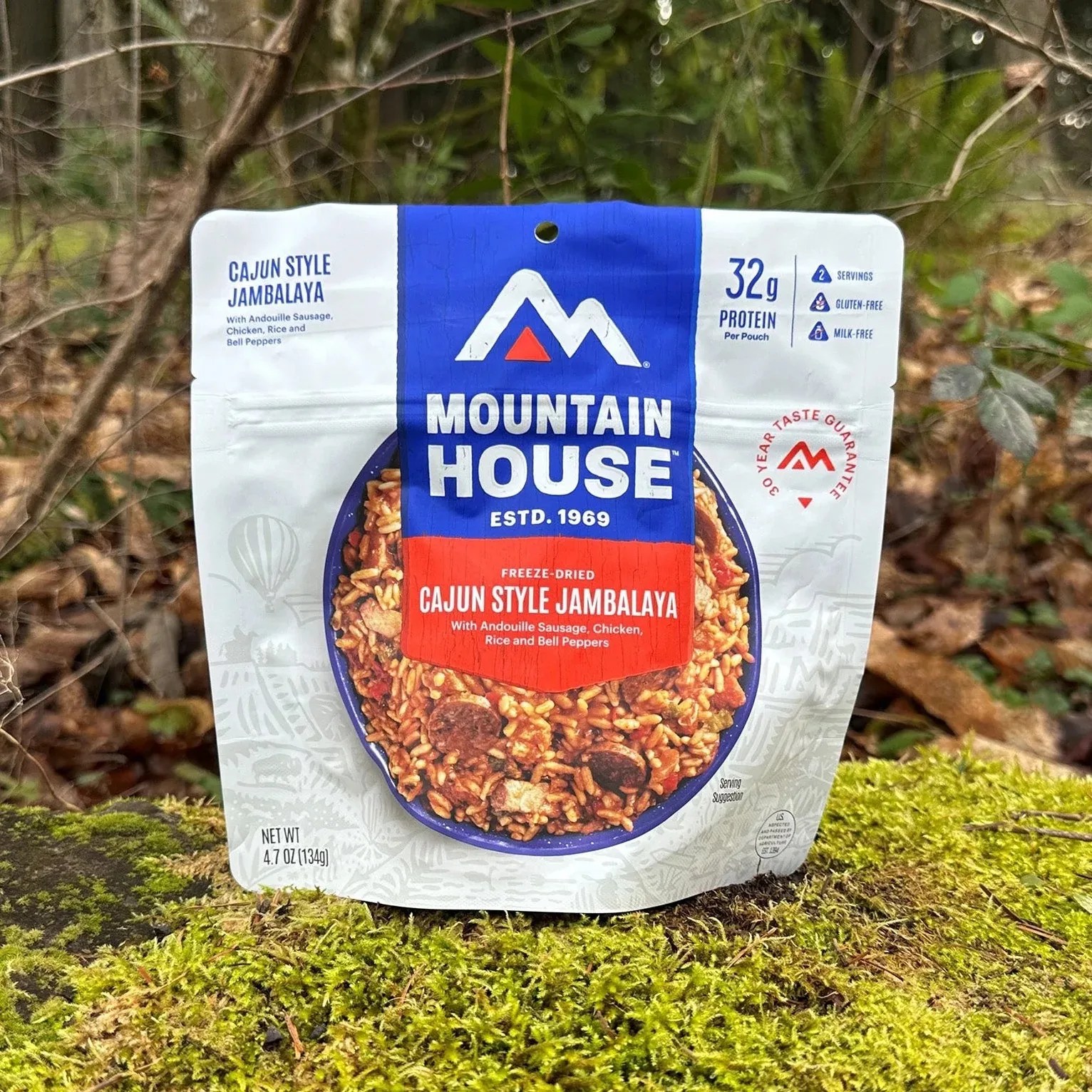 Freeze-dried Cajun style jambalaya meal pouch from Mountain House on mossy ground outdoors.