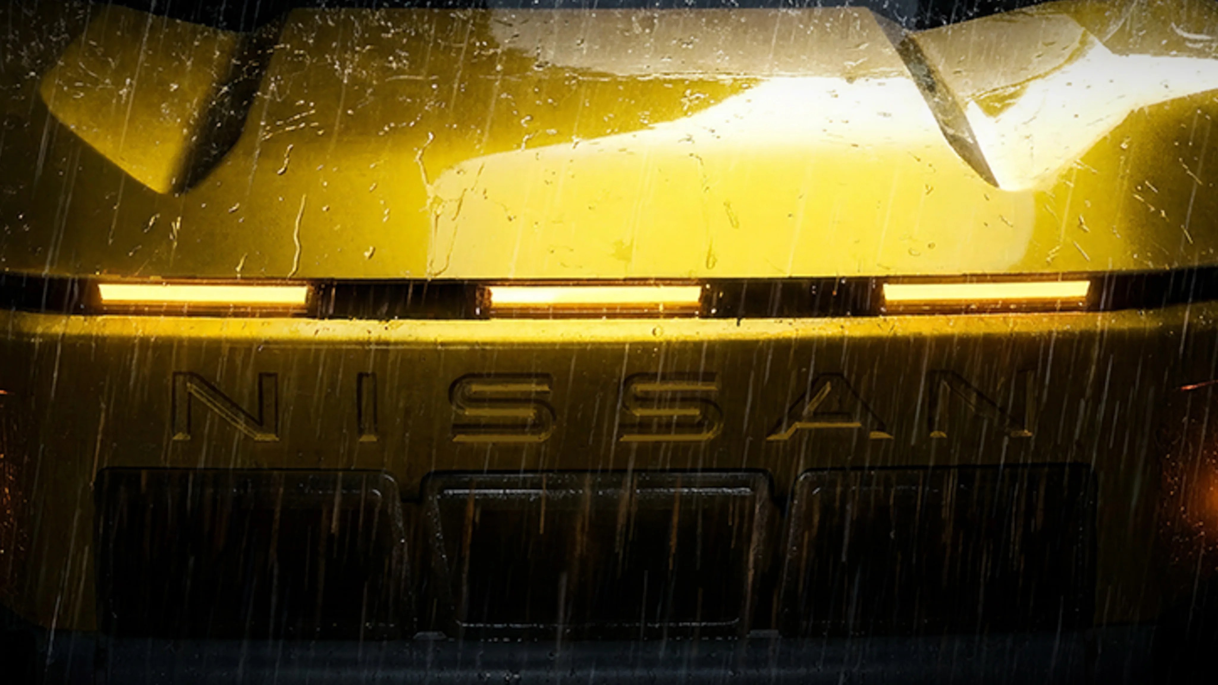 Front view of a yellow Nissan car with illuminated horizontal headlights in the rain.