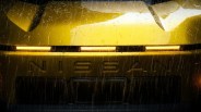 Front view of a yellow Nissan car with illuminated horizontal headlights in the rain.