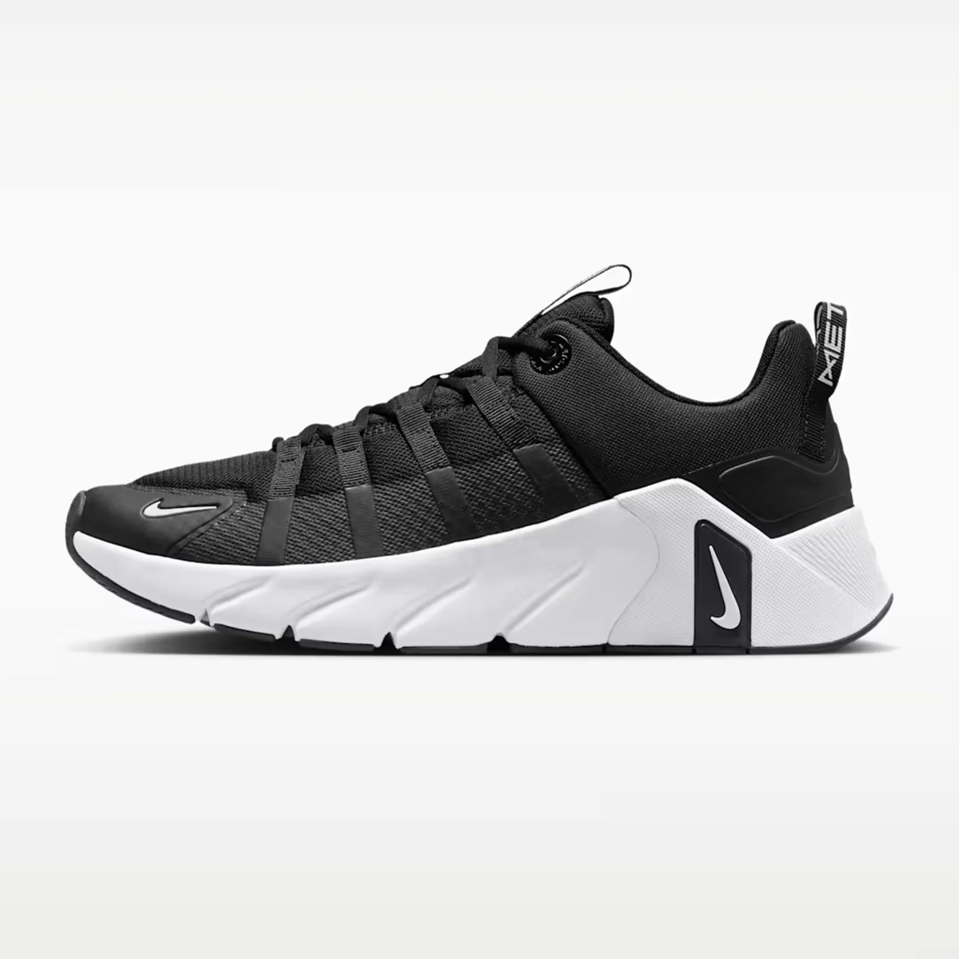Black and white Nike athletic shoe with mesh upper and thick white sole.