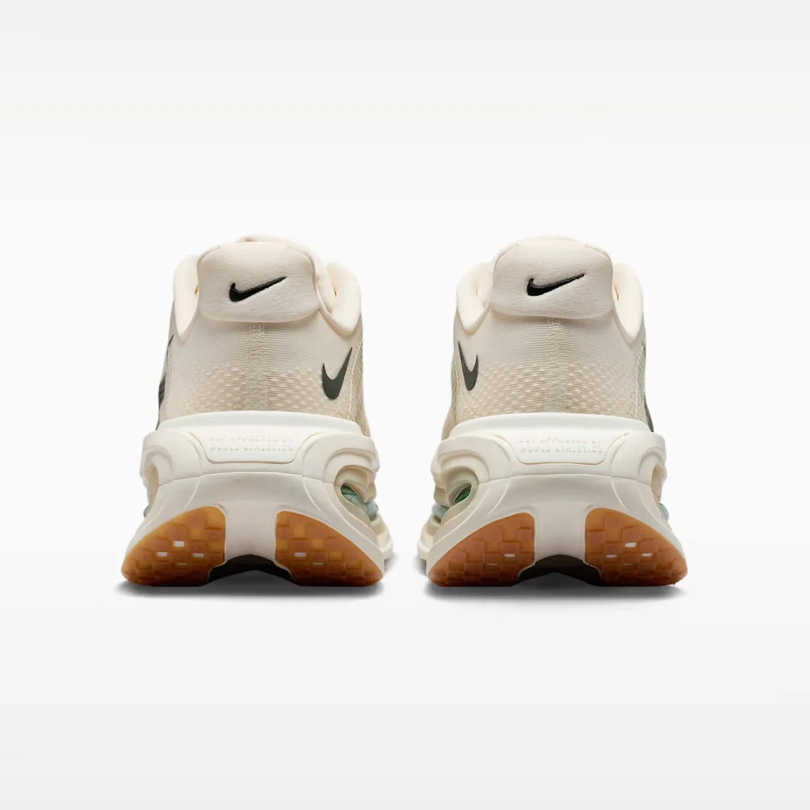 Pair of off-white Nike sneakers shown from the back with black swoosh logos and gum-colored soles.