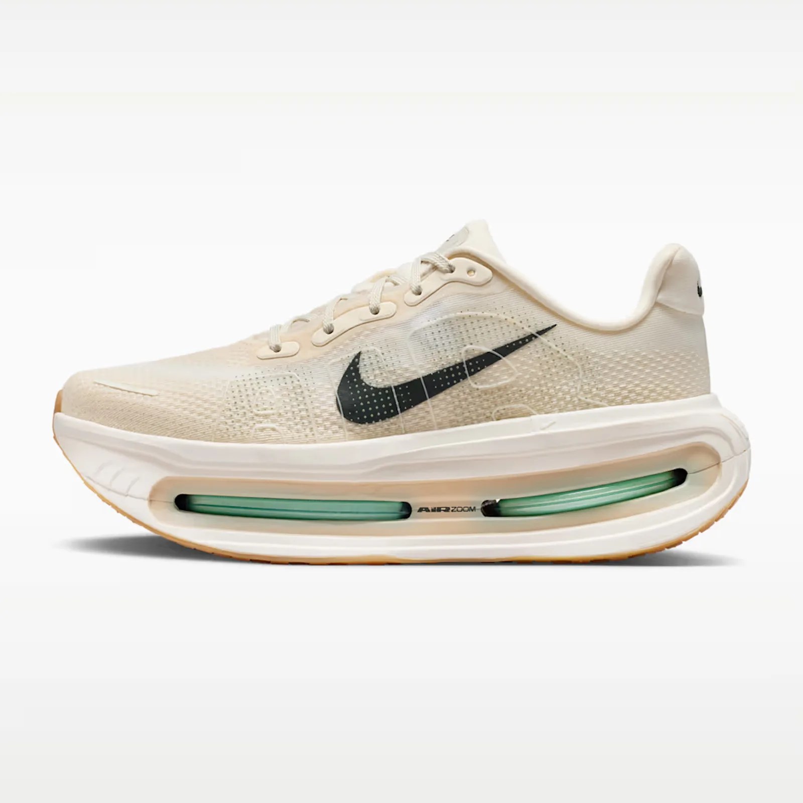 Beige Nike Air Zoom running shoe with black swoosh and visible green air cushion in sole.