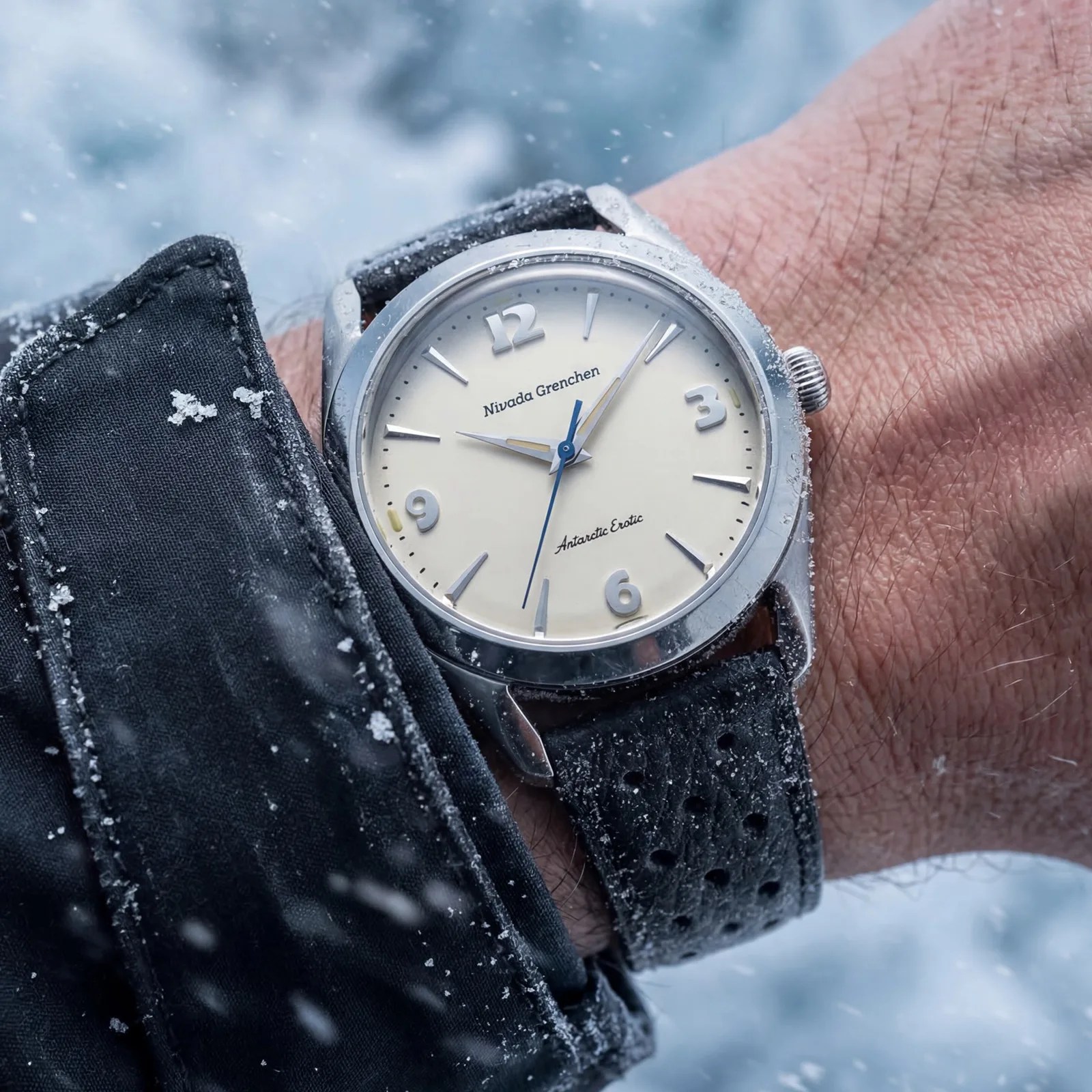 Silver Nivada Grenchen Antarctic Exotic wristwatch with cream dial and black perforated leather strap worn in snowy conditions.