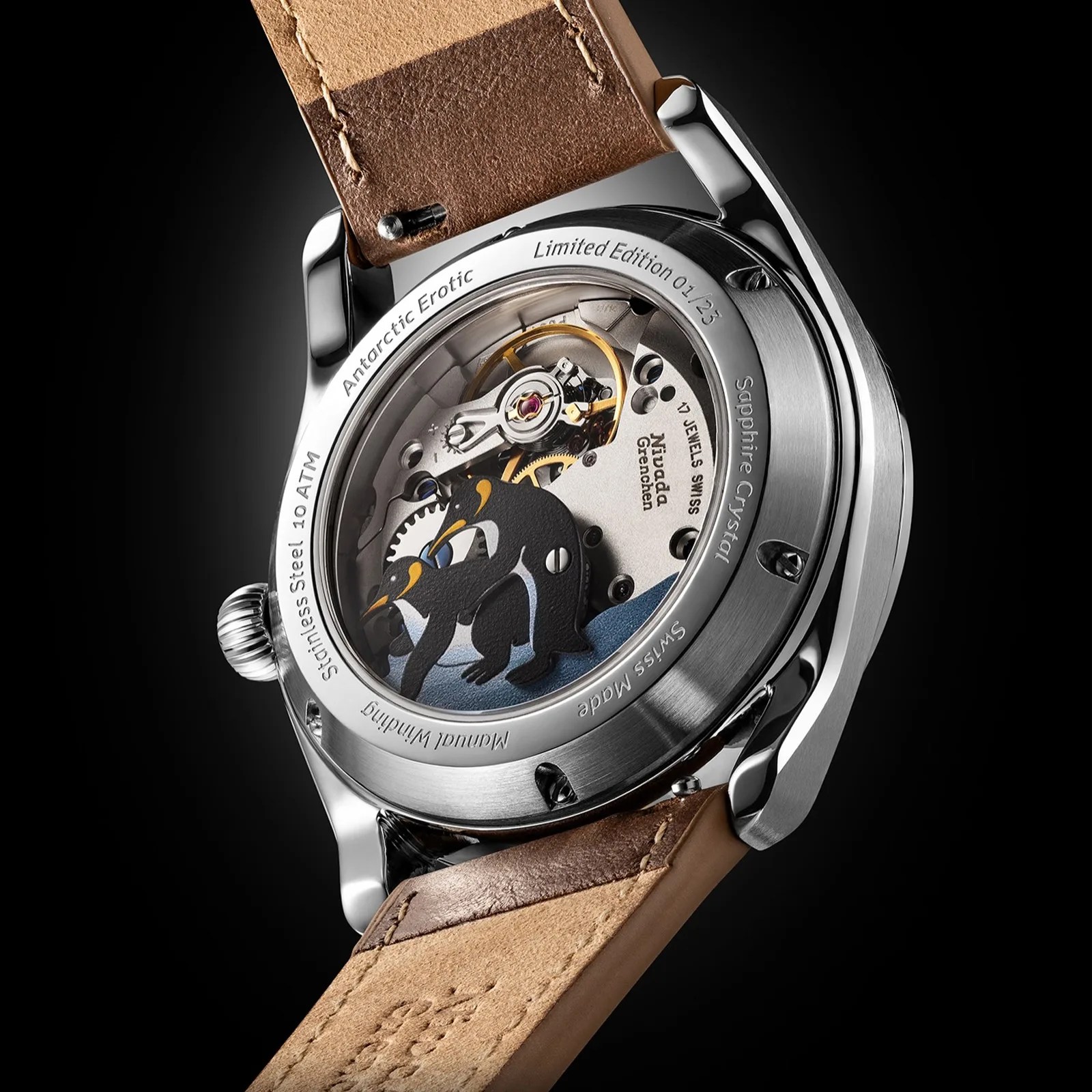 Back of a stainless steel wristwatch with visible mechanical movement and penguin design under sapphire crystal, brown leather strap.