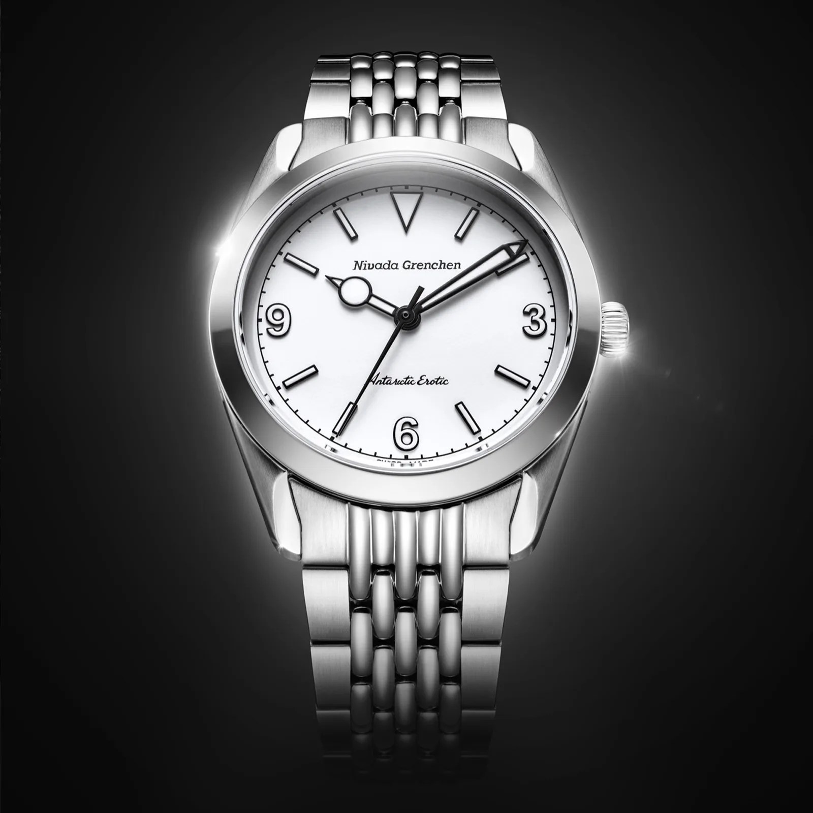 Silver stainless steel wristwatch with white dial, black hour markers, and "Nivada Grenchen Antarctic Erotic" text.
