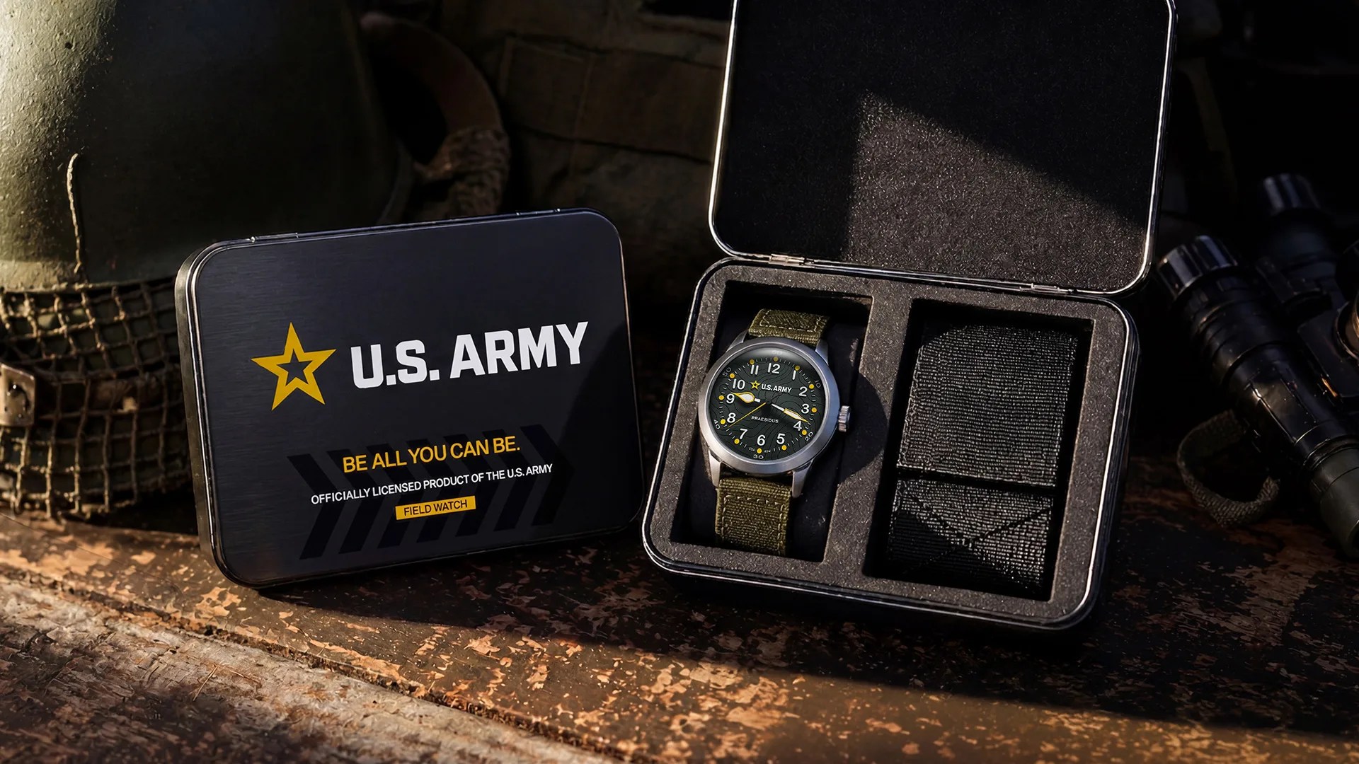 U.S. Army field watch with green fabric strap in black foam-lined metal case next to a closed case with U.S. Army logo.