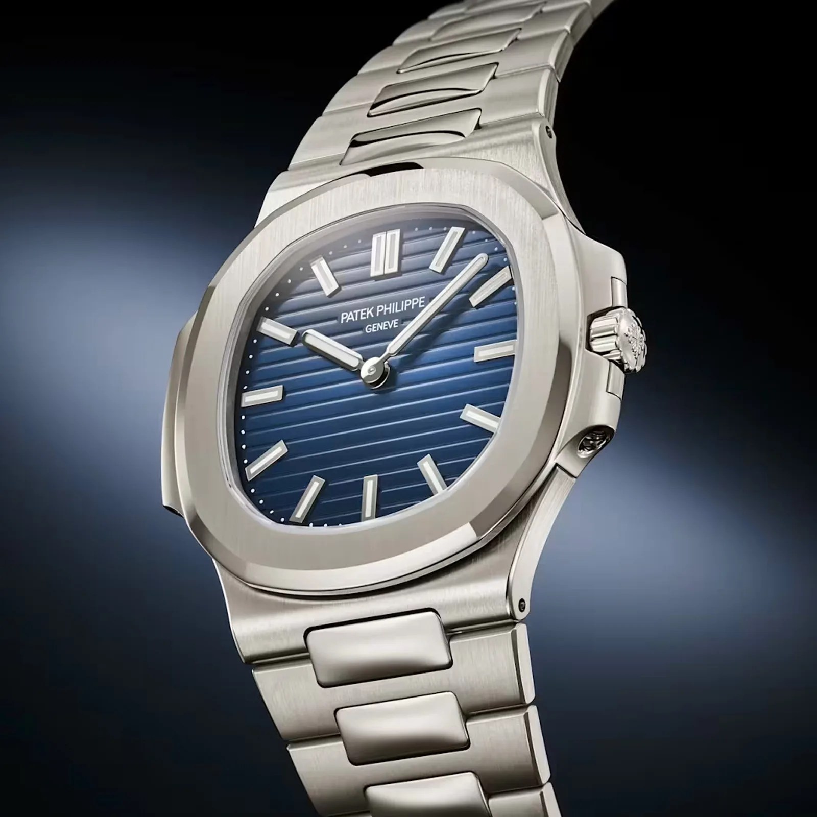 Silver stainless steel Patek Philippe watch with a blue horizontal striped dial and silver hour markers.
