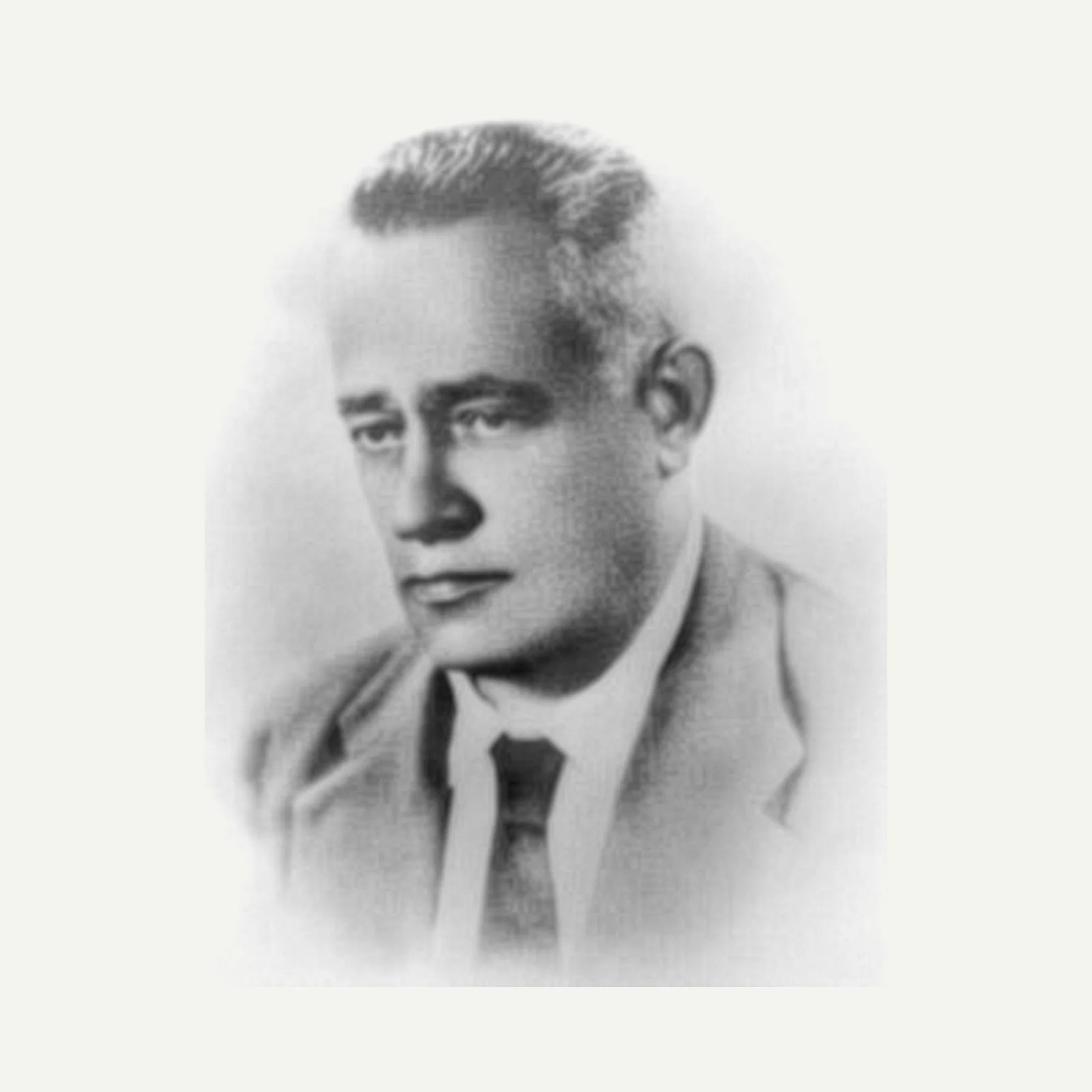 Black and white portrait of a man in a suit and tie with slicked-back hair.