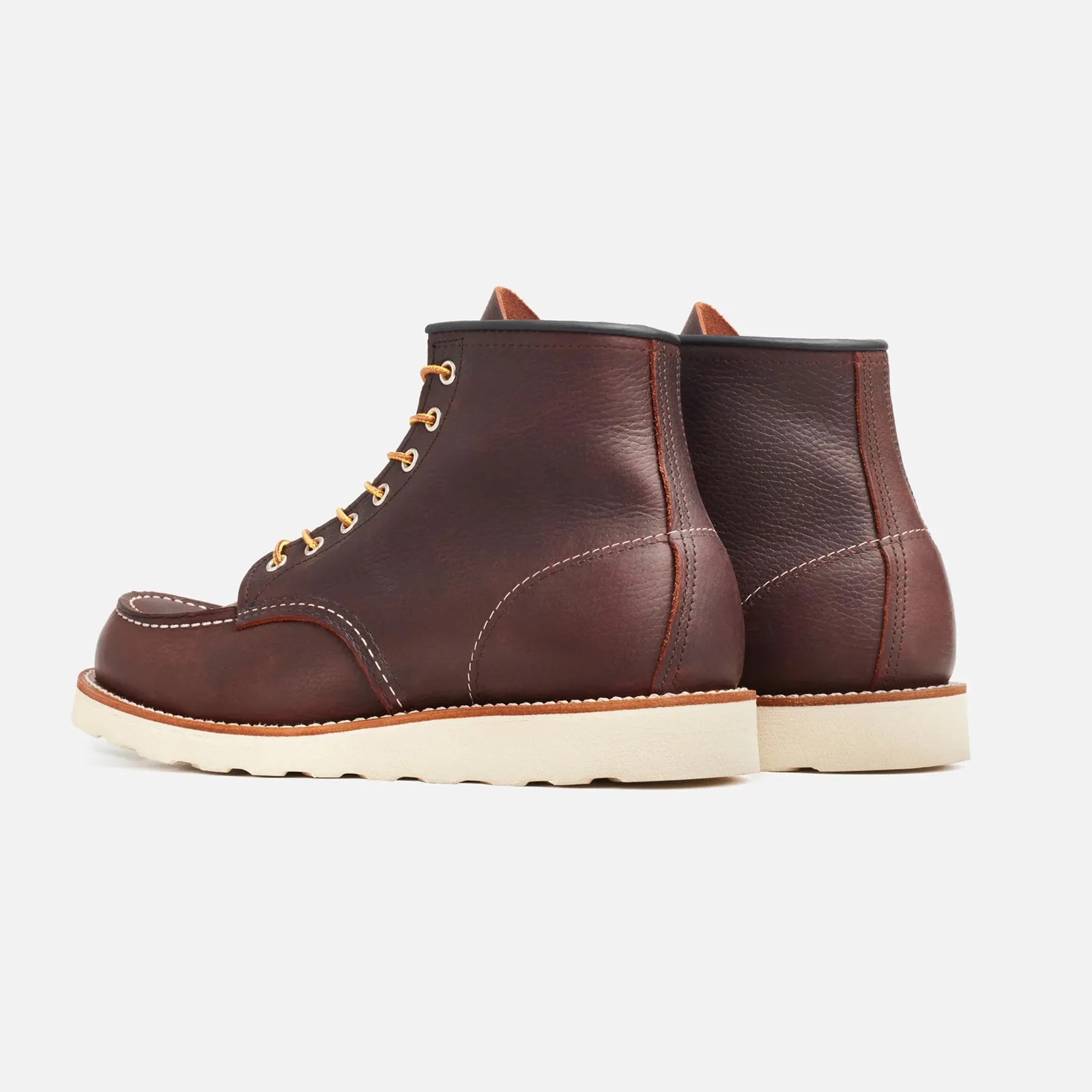 Pair of dark brown leather moc toe boots with white stitching and cream-colored rubber soles.