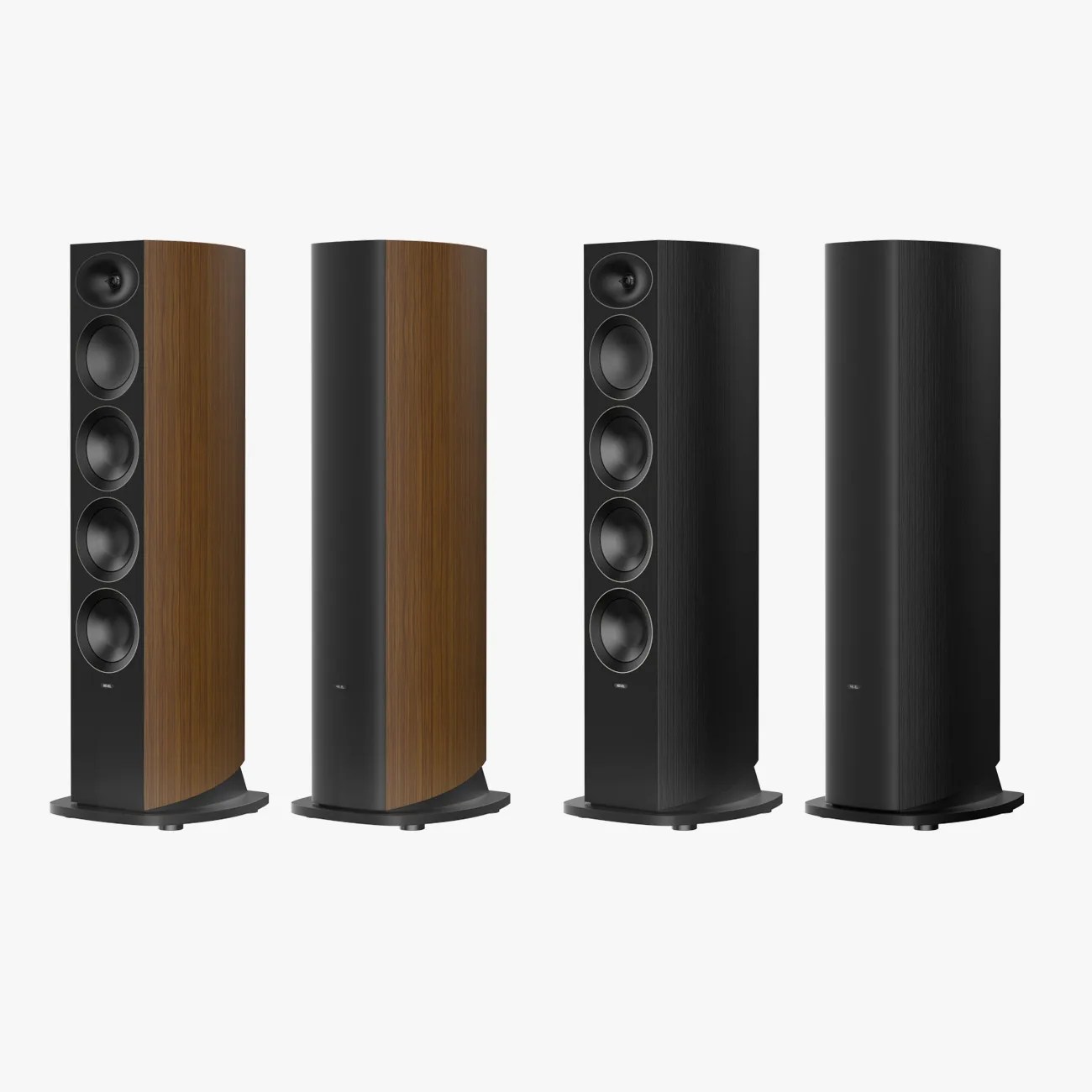Four tall floor-standing speakers, two with wood finish and two with black finish, each with four circular drivers on the front.