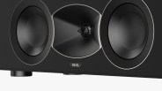 Close-up of a black Revel speaker with two large drivers and a central horn tweeter.