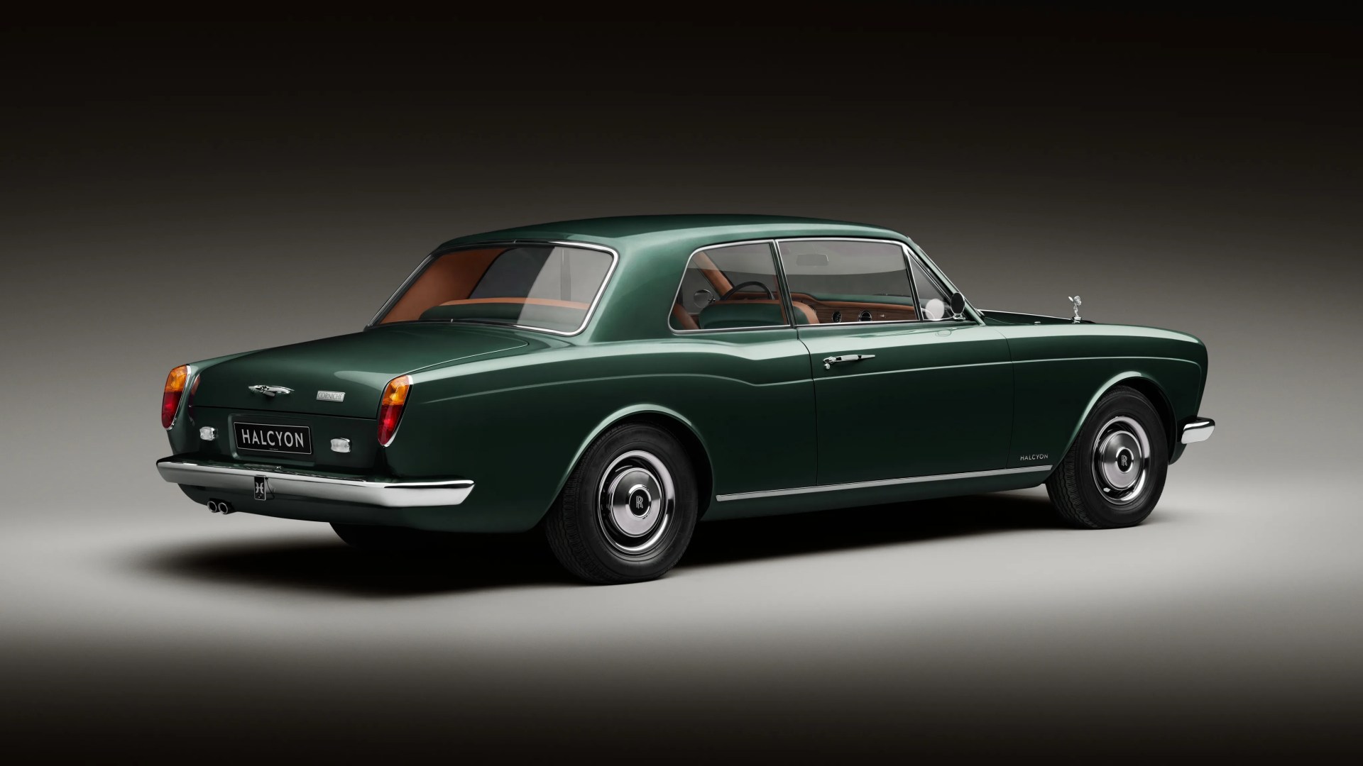 Dark green classic Rolls-Royce Halcyon coupe with tan leather interior shown from rear side.