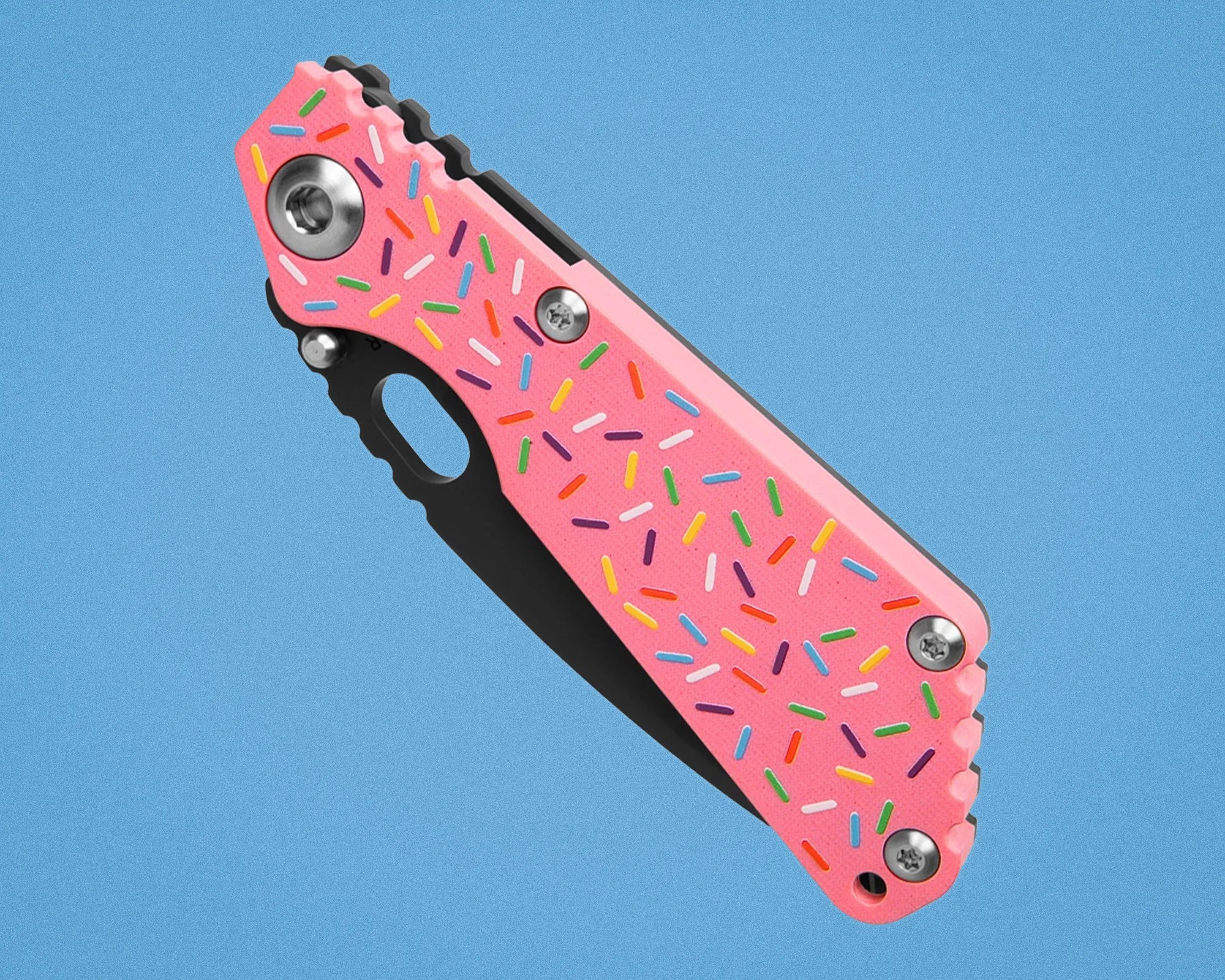 Pink folding knife handle with colorful sprinkle pattern and metal screws on a blue background.