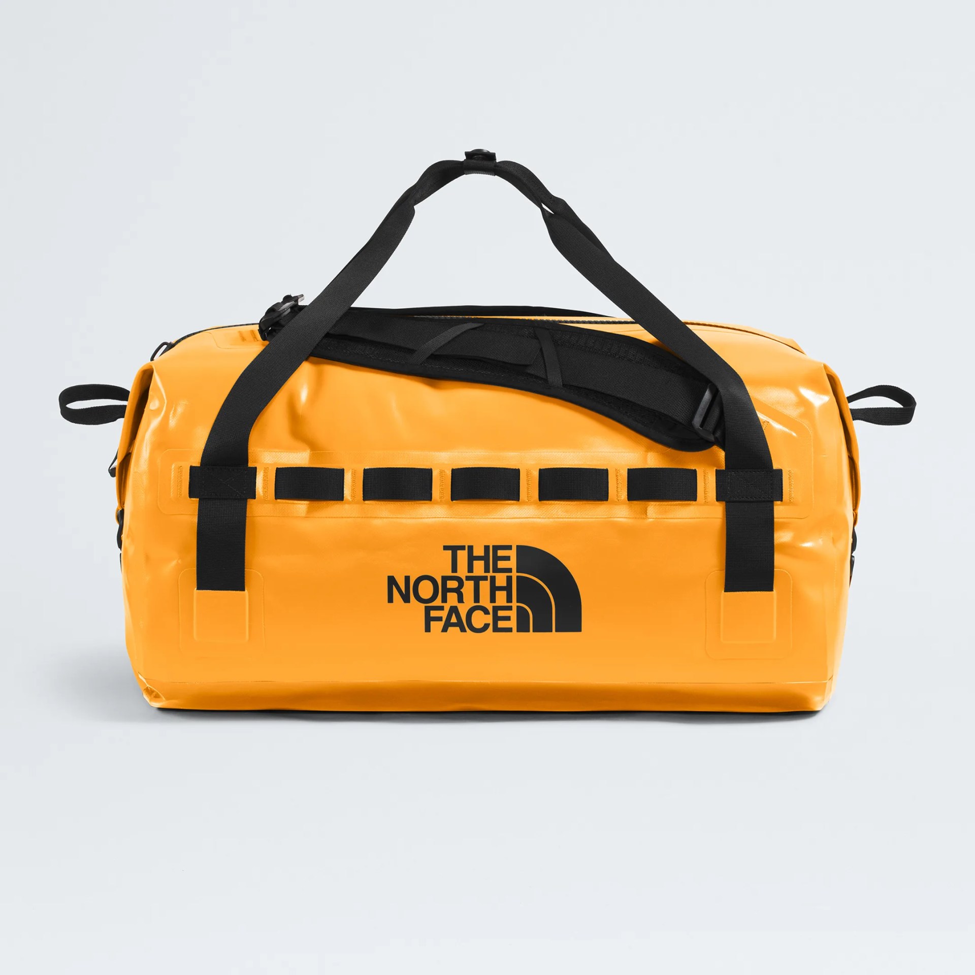 Bright orange waterproof duffel bag with black straps and The North Face logo on front.