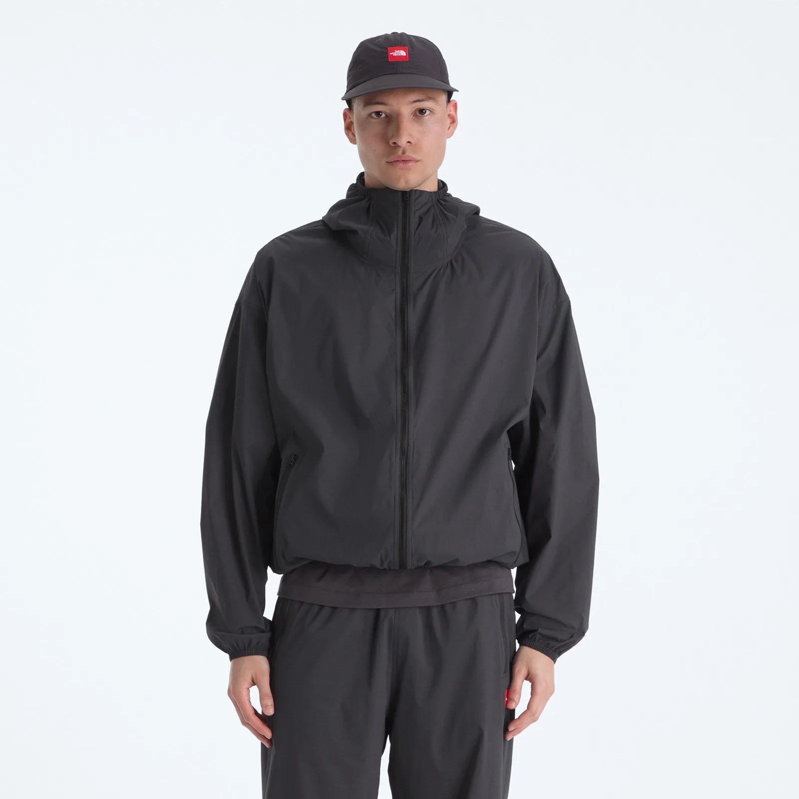 Black zip-up hooded jacket with elastic cuffs worn by a person.