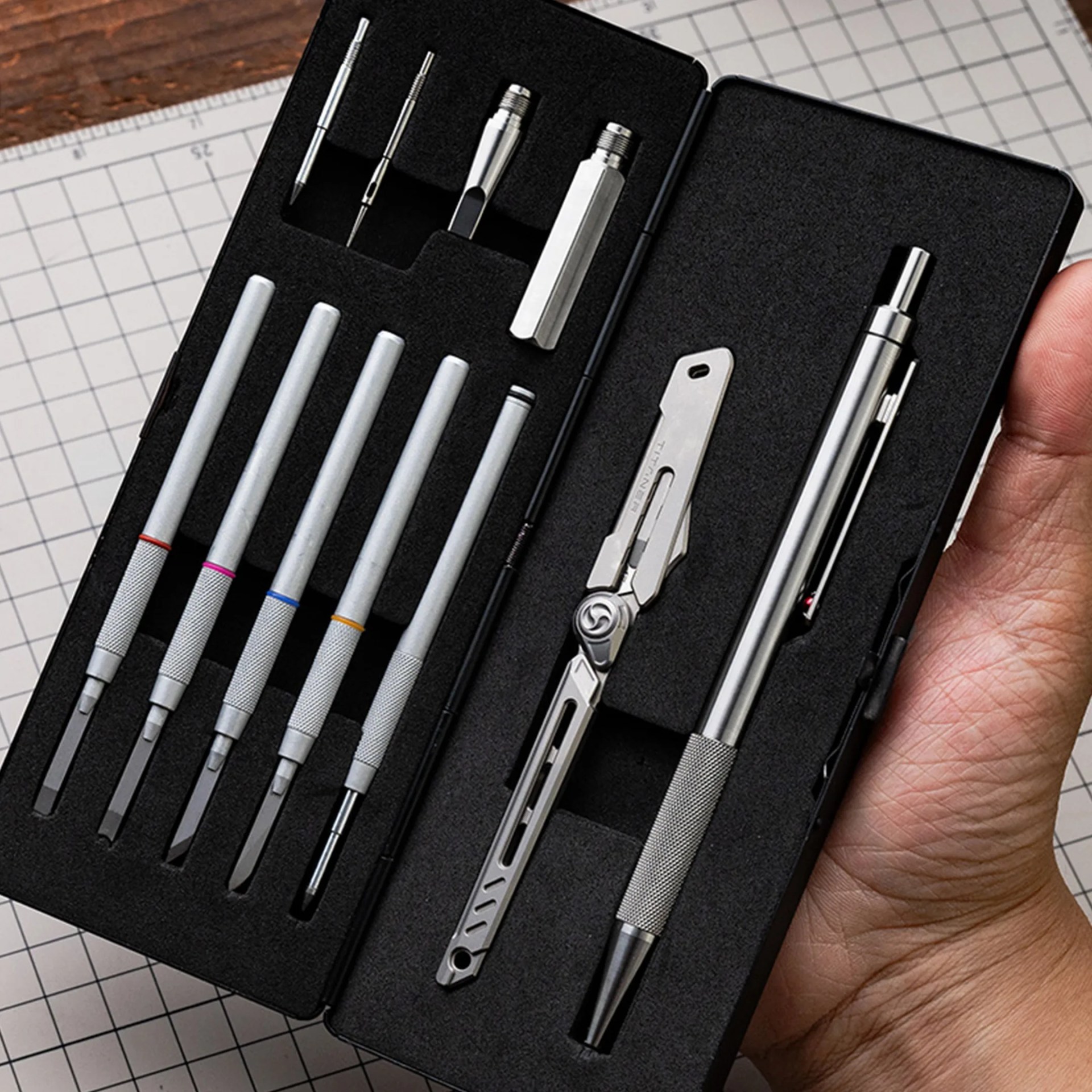 Black foam-lined case holding a precision screwdriver set with multiple metal bits and tools.