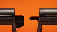 Two black Traeger grills facing each other against an orange background, one showing a digital display reading 450°.