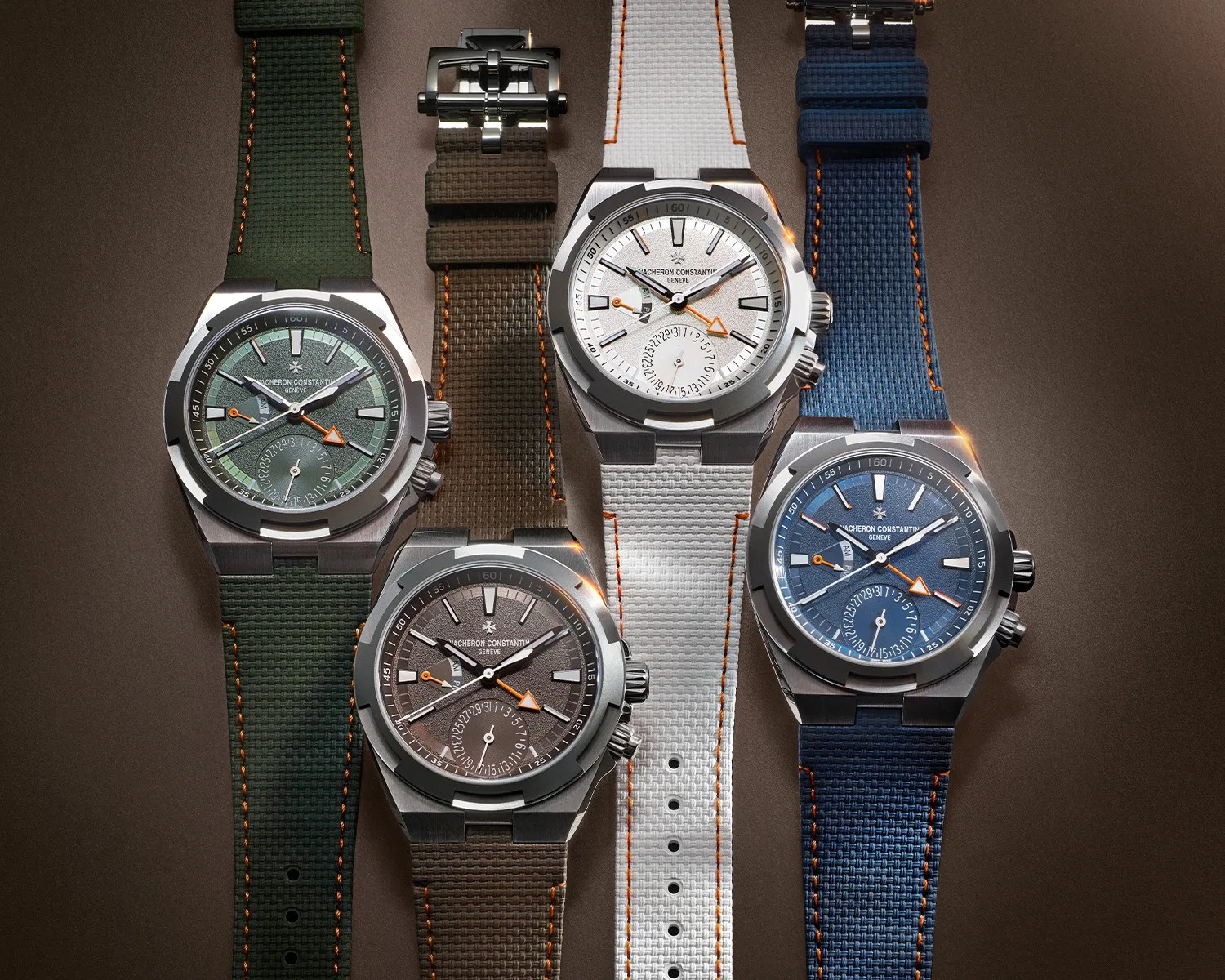 Four Vacheron Constantin wristwatches with textured dials in green, brown, white, and blue, each with matching rubber straps and orange stitching.