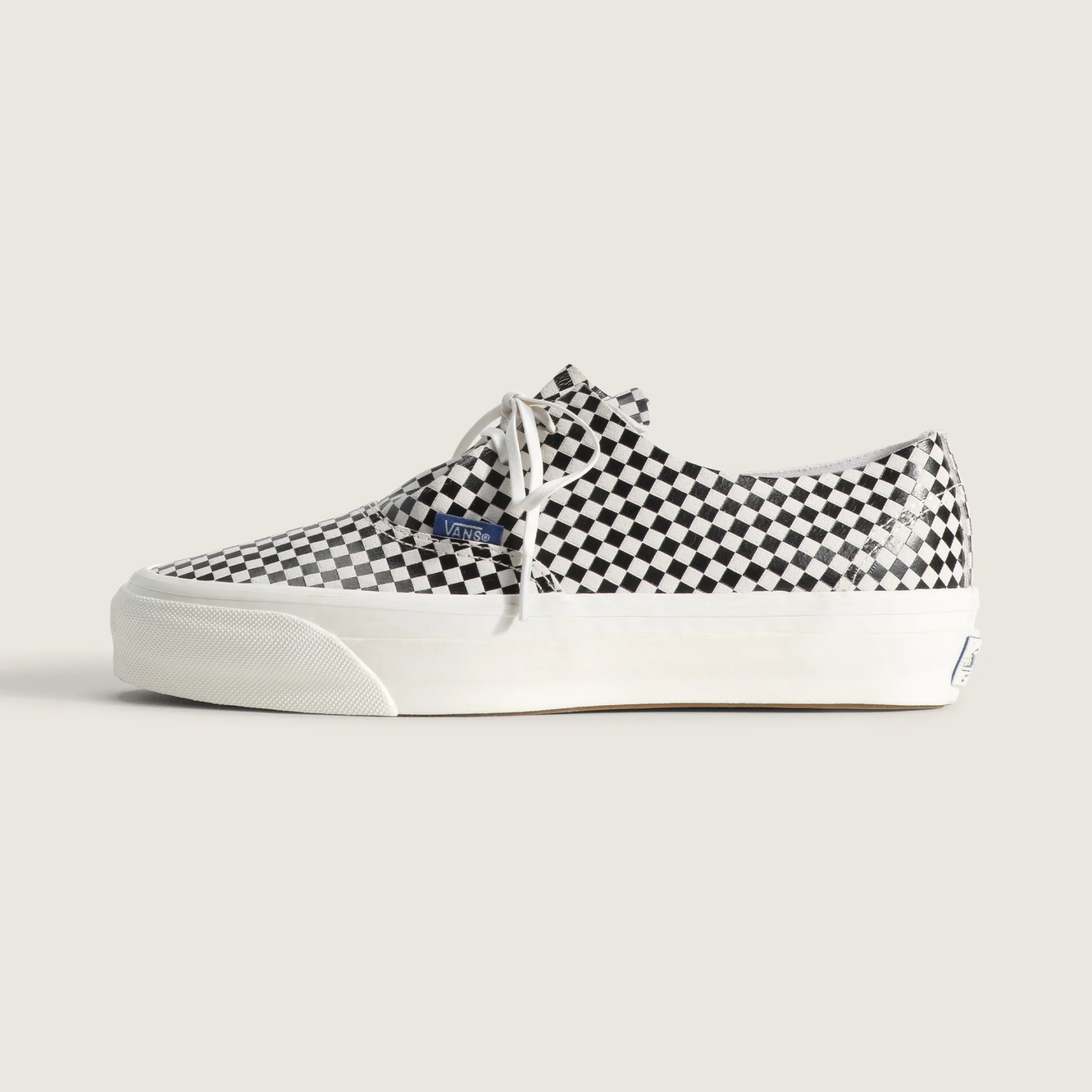 Black and white checkered Vans sneaker with white laces and thick white sole.