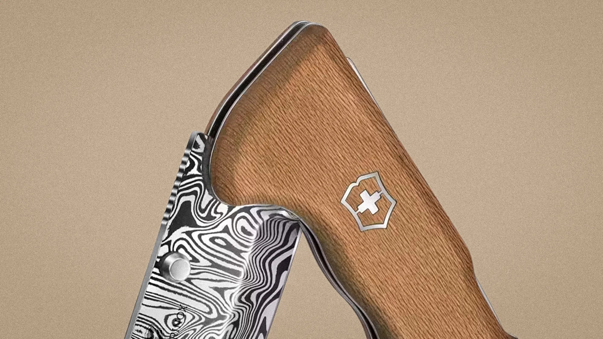 Close-up of a folding knife with a wood-textured handle featuring a silver cross emblem and a patterned black-and-white blade.