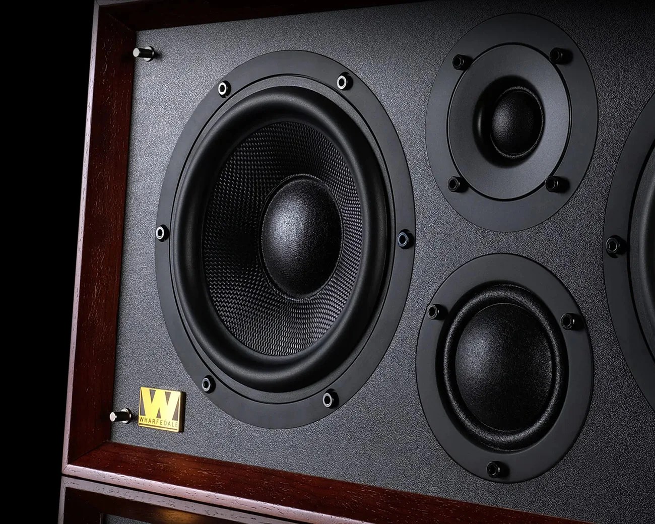 Close-up of a Wharfedale speaker with a large woofer and two smaller drivers in a wooden frame.