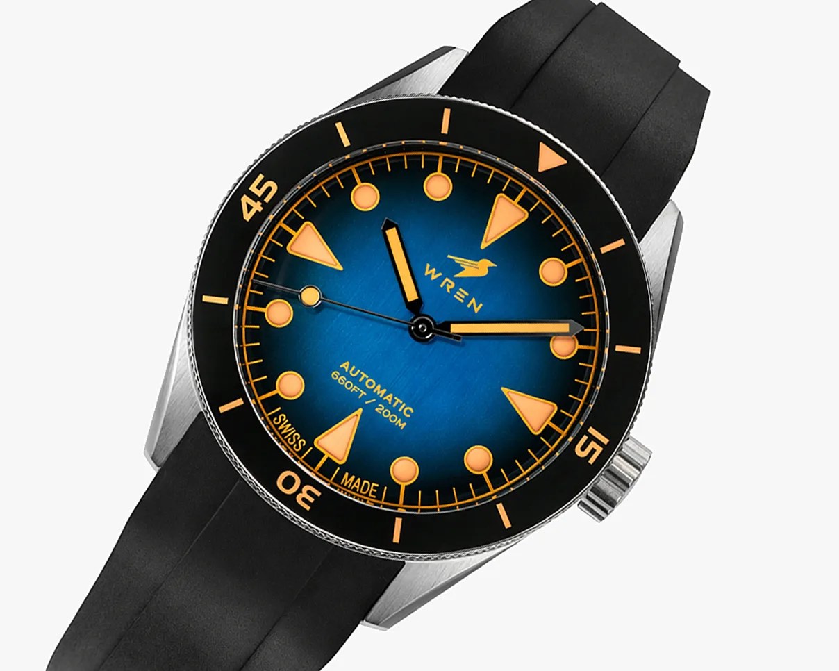 Diver-style wristwatch with blue dial, orange markers, black bezel, and black rubber strap.
