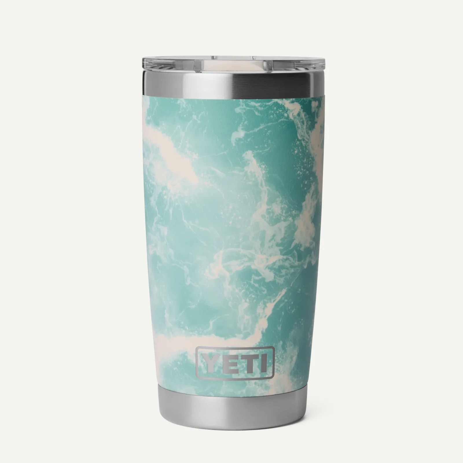 Stainless steel YETI tumbler with aqua and white ocean wave pattern and clear lid.