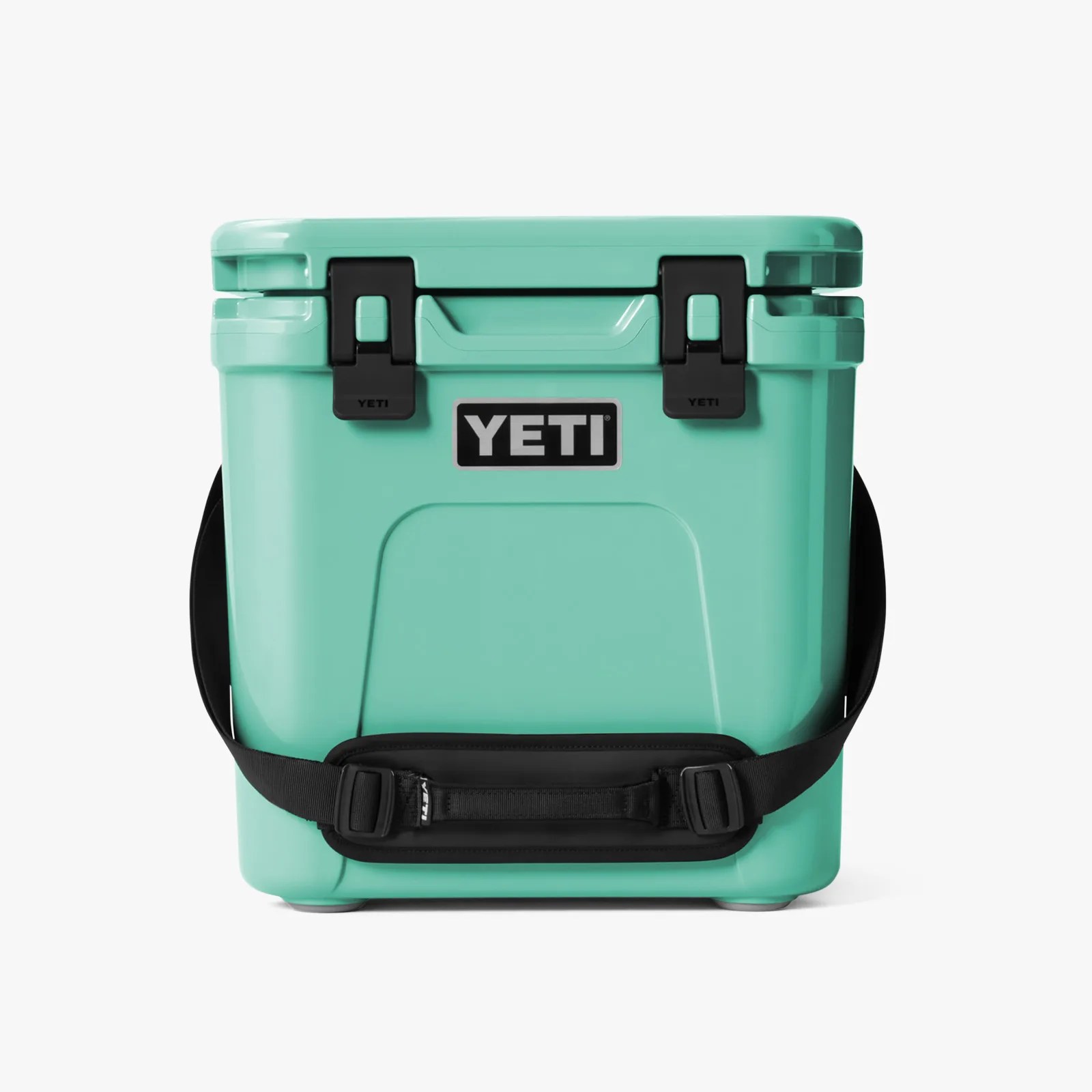 Teal YETI cooler with black latches and an adjustable black shoulder strap.