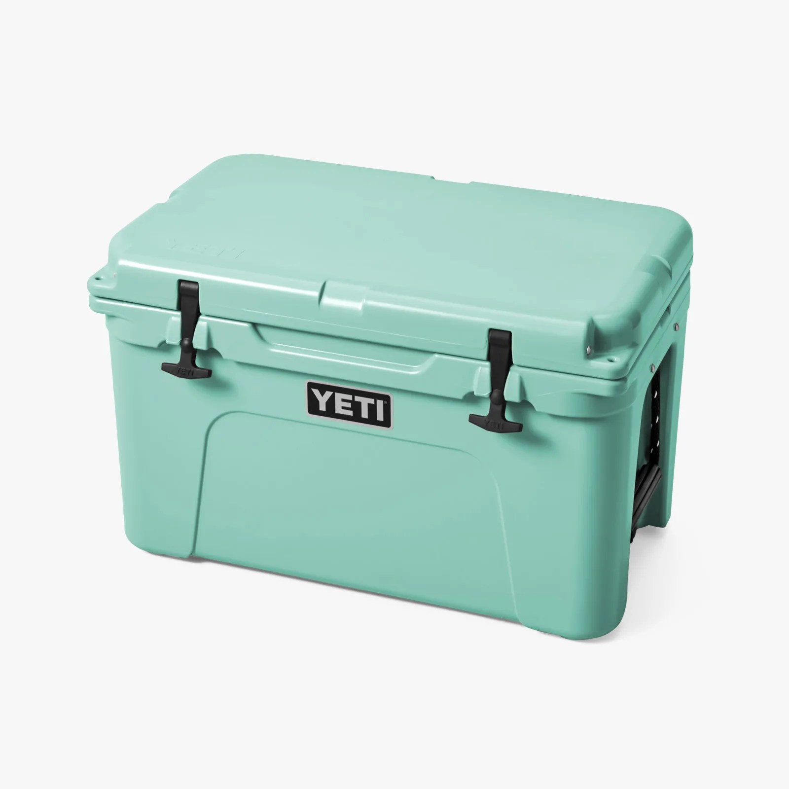 Light teal YETI cooler with black rubber latches and side handles.