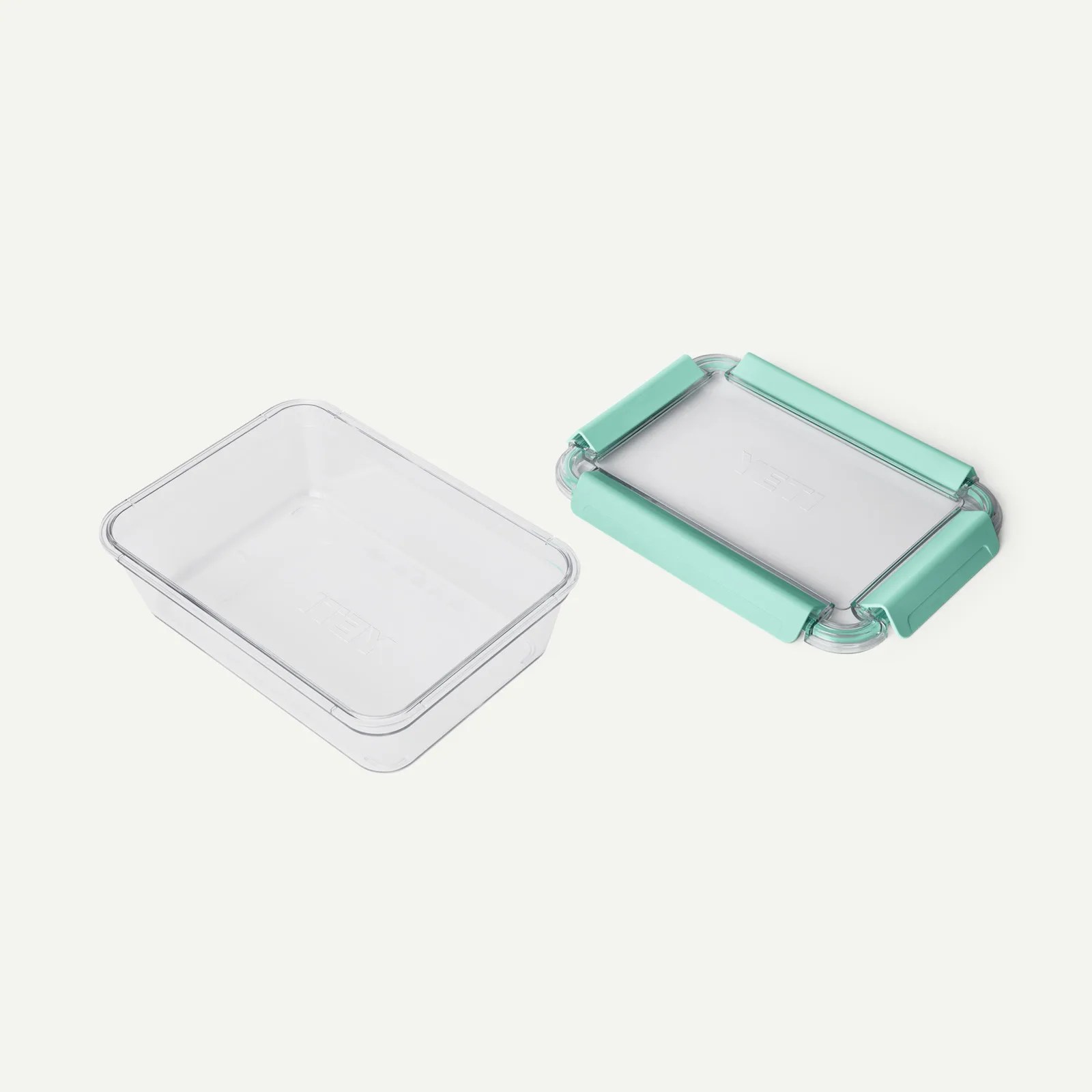 Clear rectangular plastic container with a matching lid featuring four turquoise silicone grips.