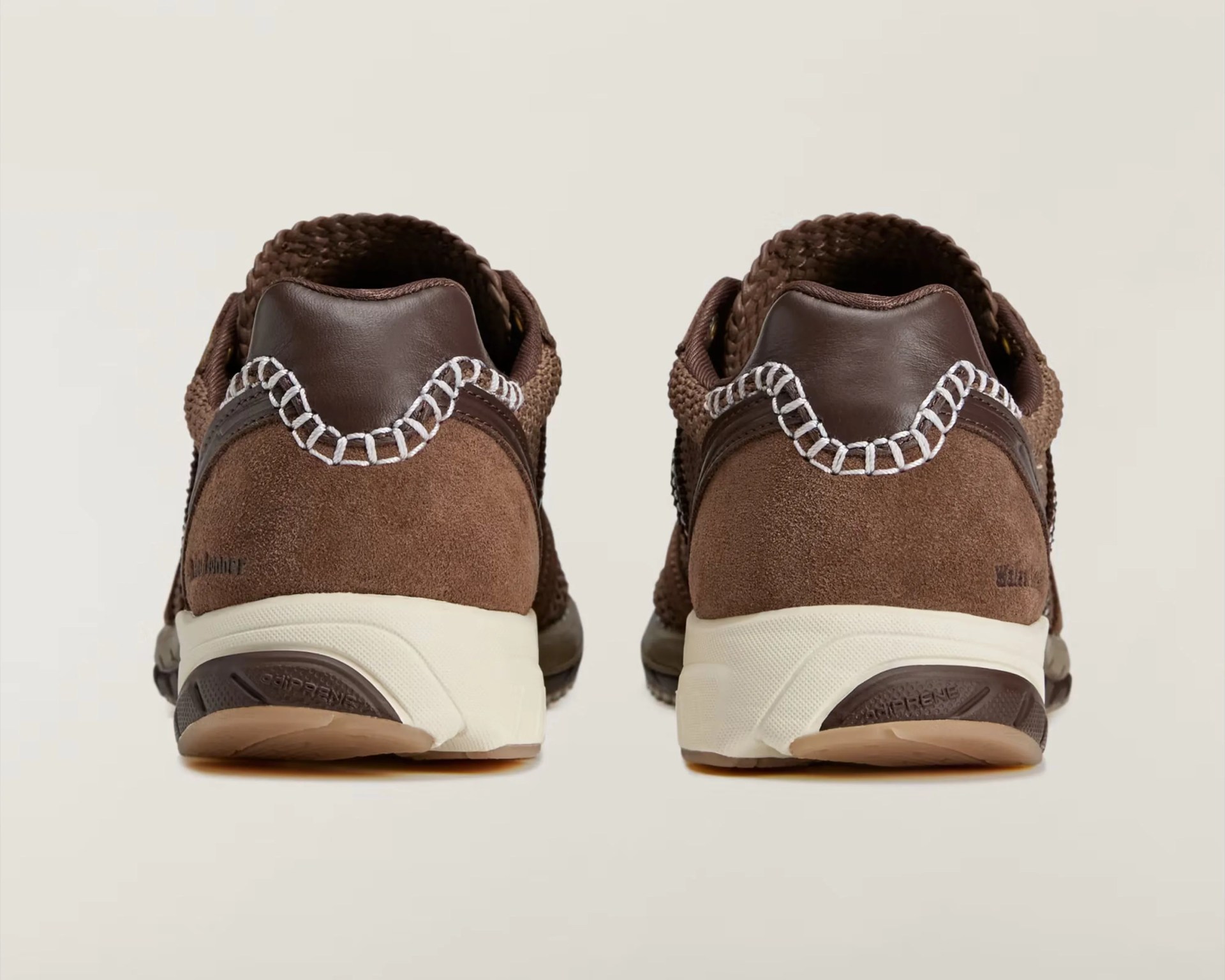 Pair of brown suede and leather sneakers with white stitching and cream soles, viewed from the back.
