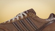 Brown Adidas sneaker with woven mesh upper, leather accents, white and brown laces, and gold eyelets.