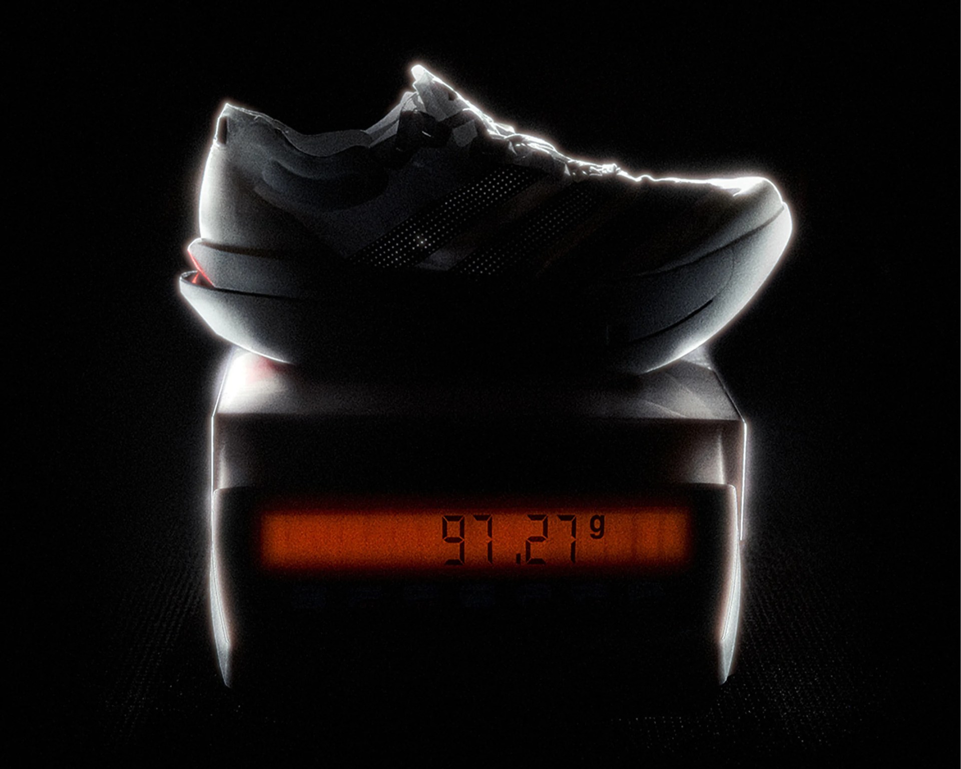 Black sneaker with reflective stripes on a digital scale showing 91.27 grams.
