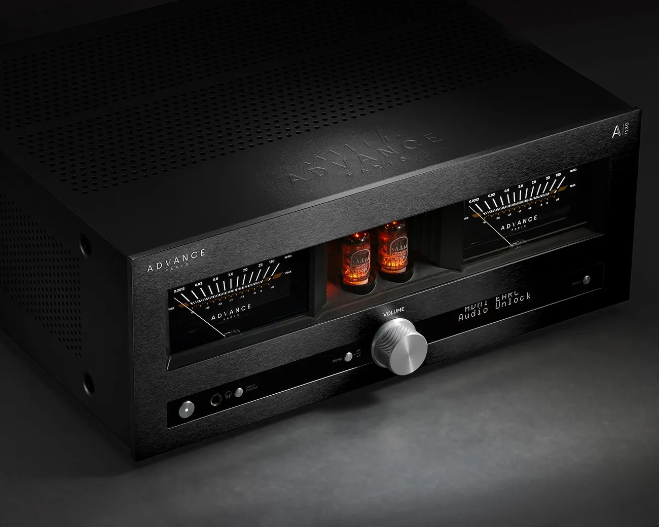 Black Advance Paris audio amplifier with glowing vacuum tubes, analog meters, and silver volume knob on a dark surface.