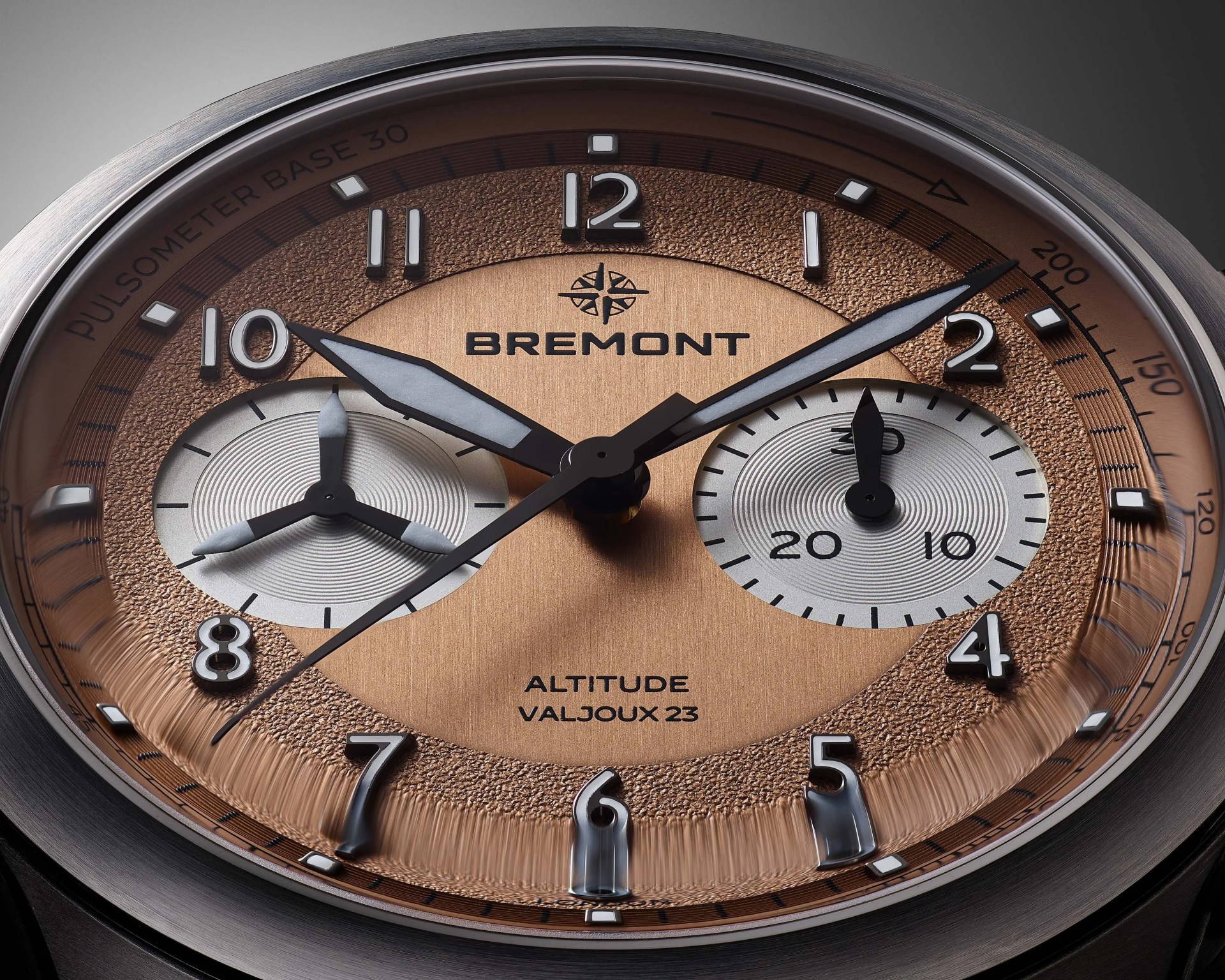 Close-up of a Bremont Altitude watch face with textured bronze dial, silver subdials, and luminescent hands and markers.