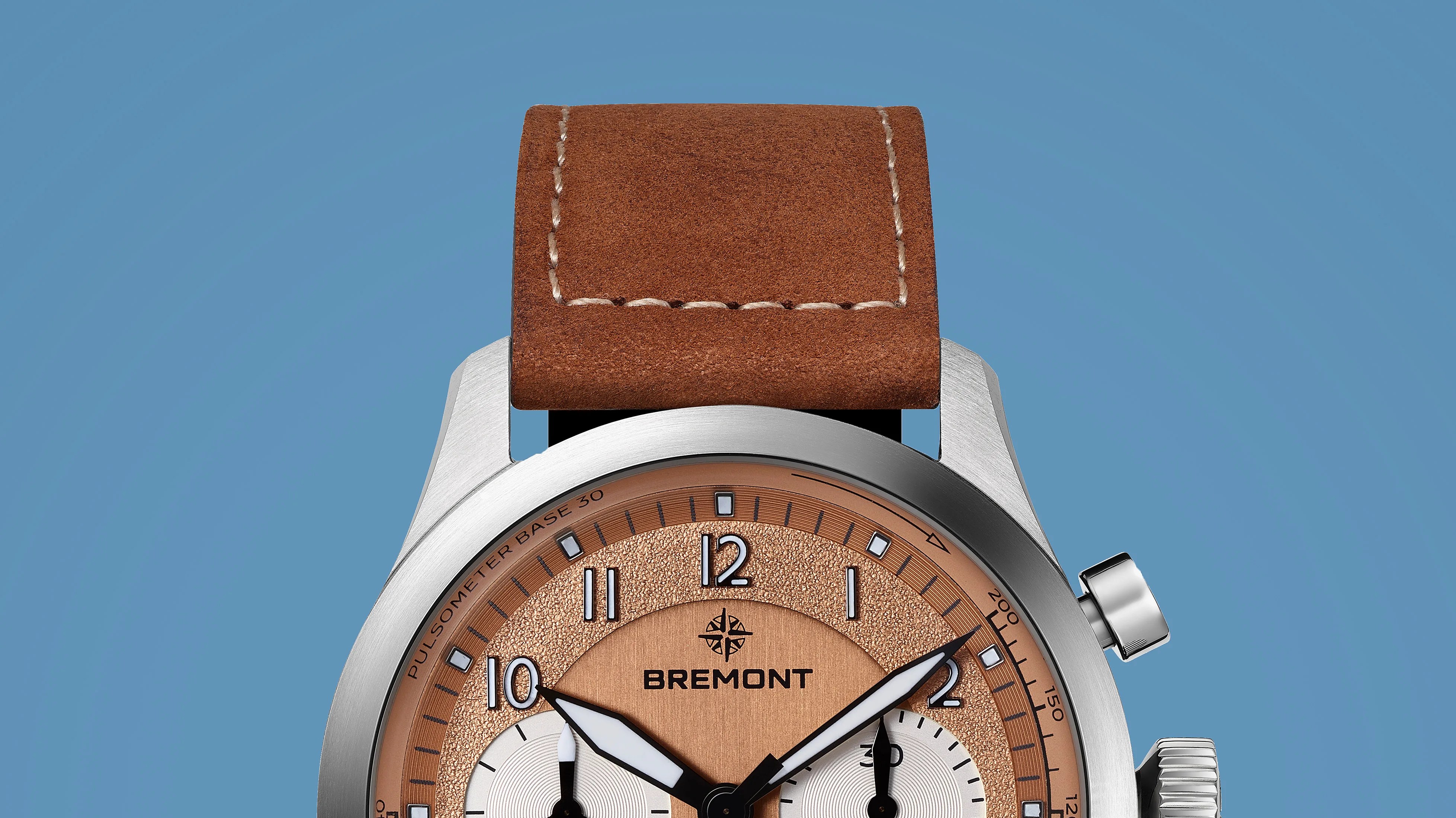 Close-up of a Bremont watch with a brown leather strap and copper-colored textured dial.