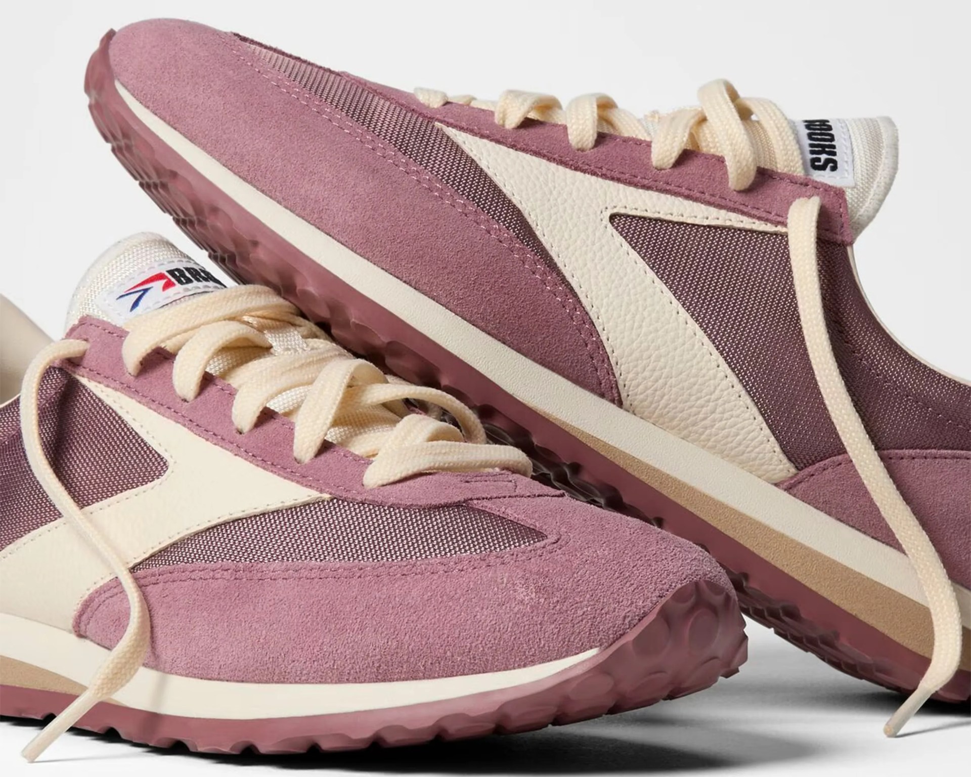 Pair of mauve and cream suede and mesh sneakers with cream laces and textured rubber soles.