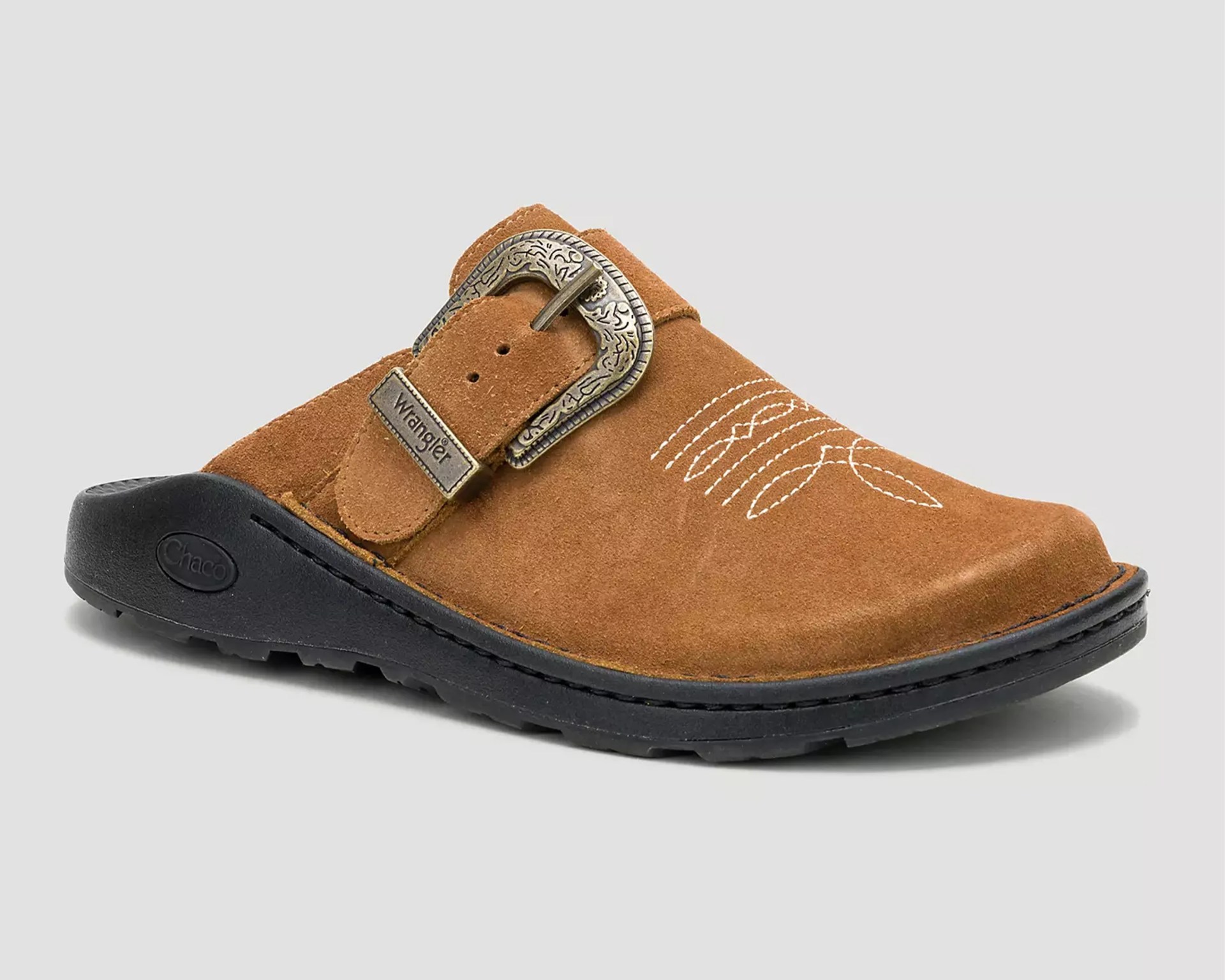 Brown suede clog with decorative white stitching, engraved metal buckle, and black sole.