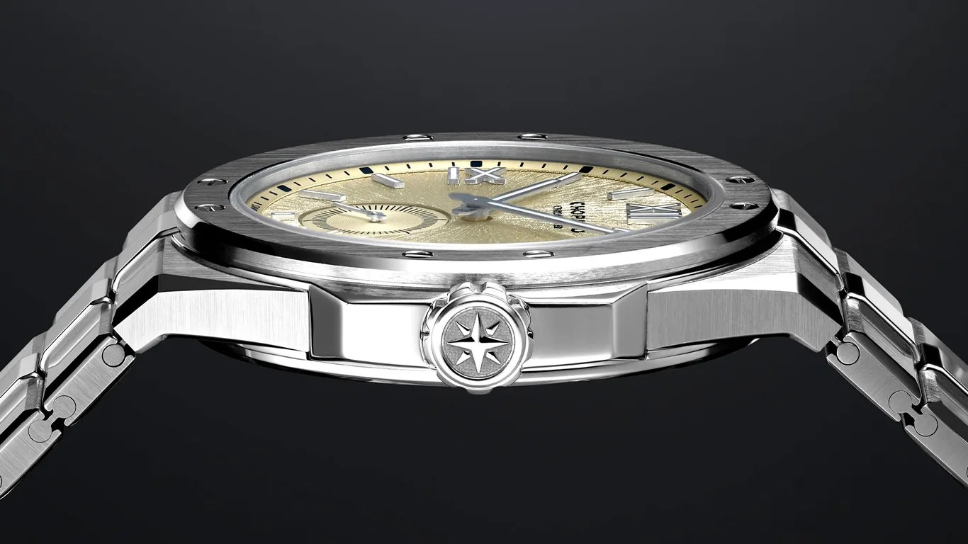 Side view of a silver metal wristwatch with a textured gold dial and a star emblem on the crown.