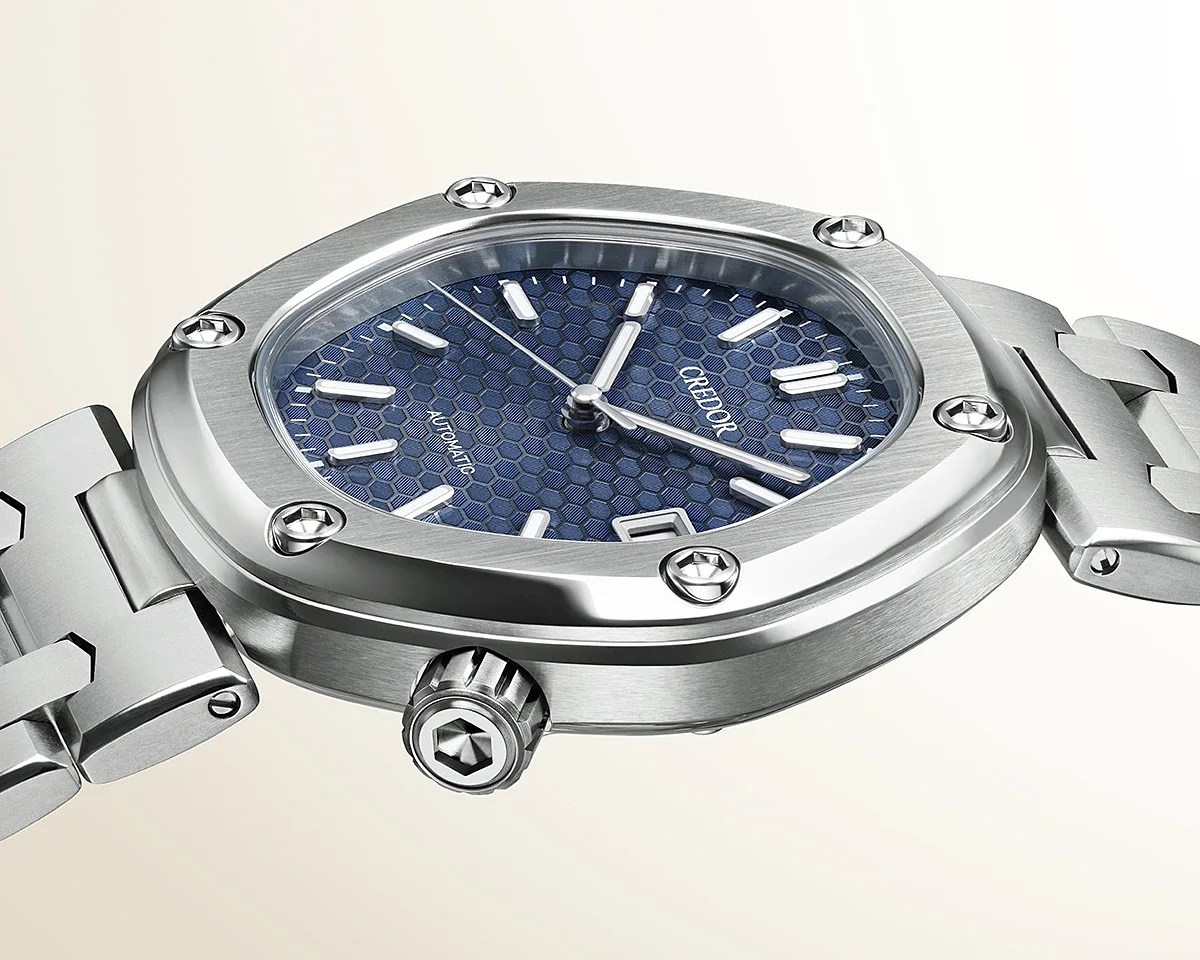 Silver stainless steel wristwatch with a blue honeycomb-patterned dial and hexagonal screws on the bezel.
