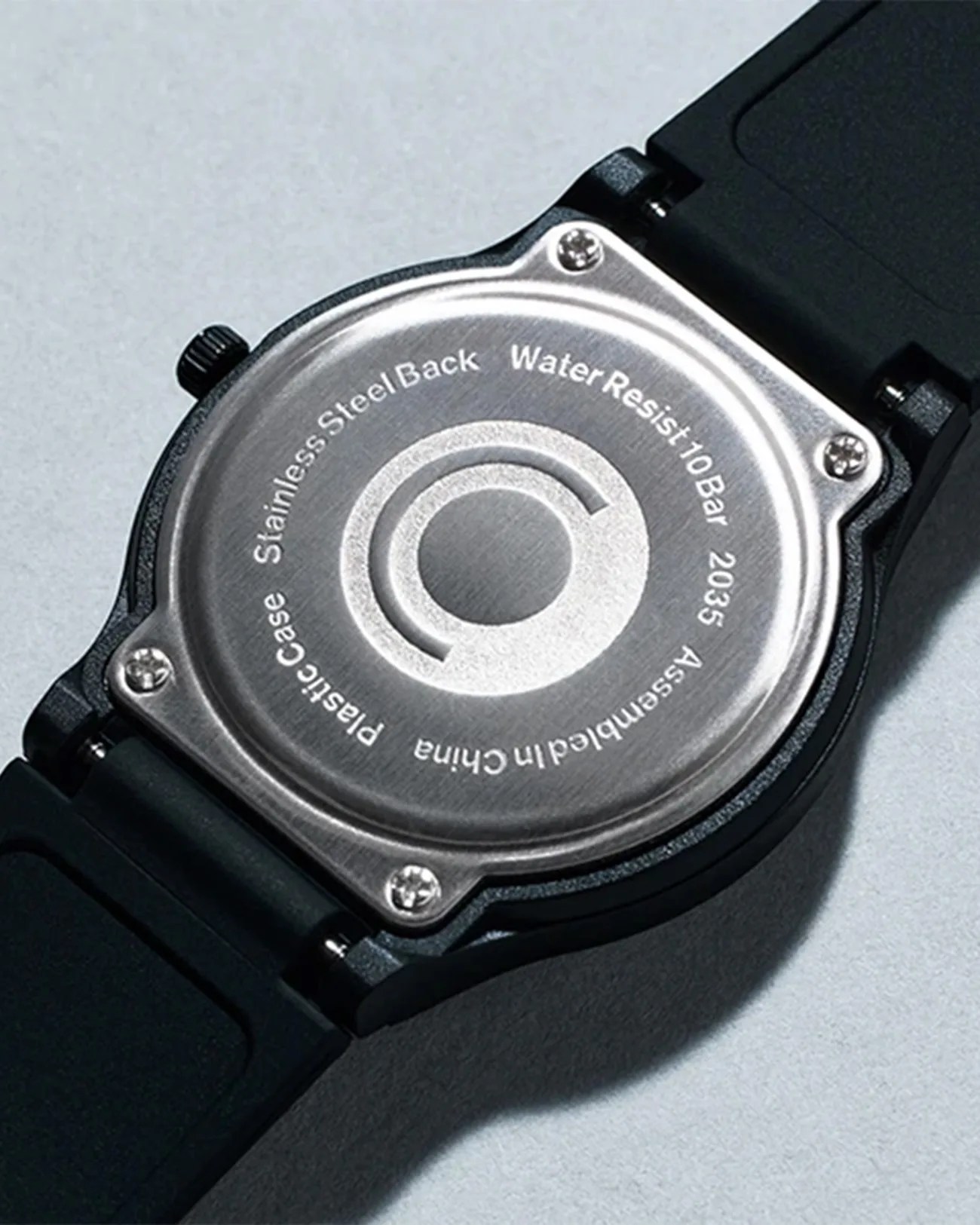 Back of a black watch with a stainless steel case back, water resistant to 10 bar, and black strap.